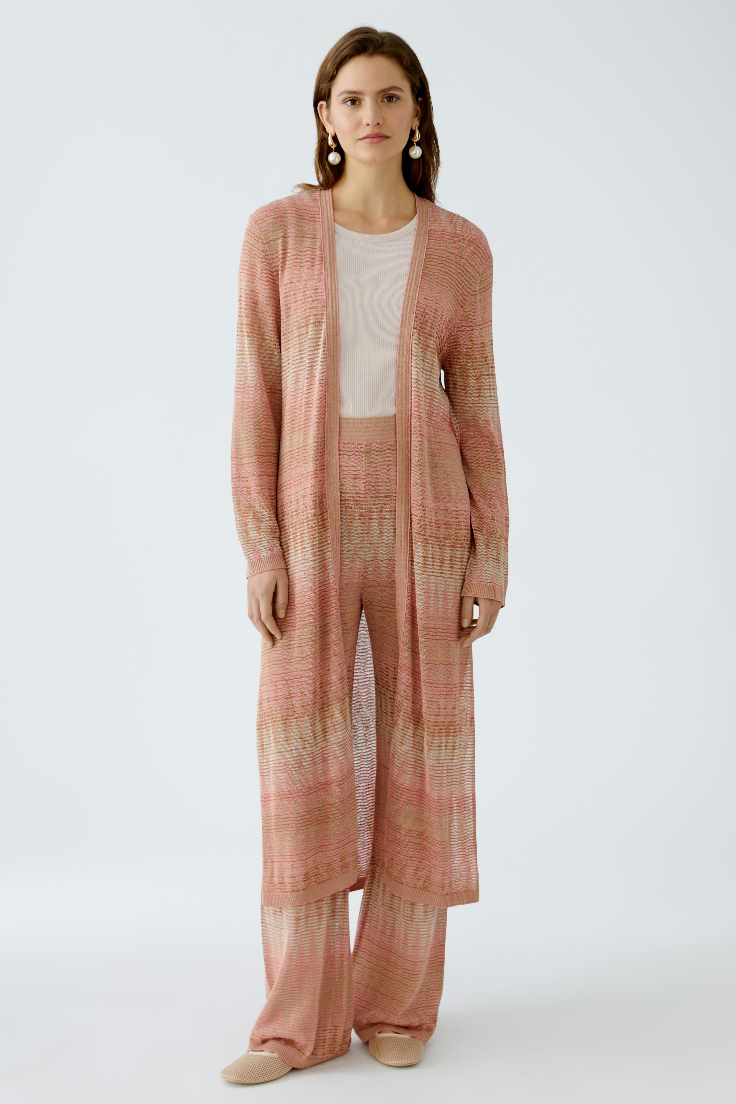 Elegante Strickhose: Frau in leichter, gestreifter Strickhose und passendem Cardigan in sanften Farben.