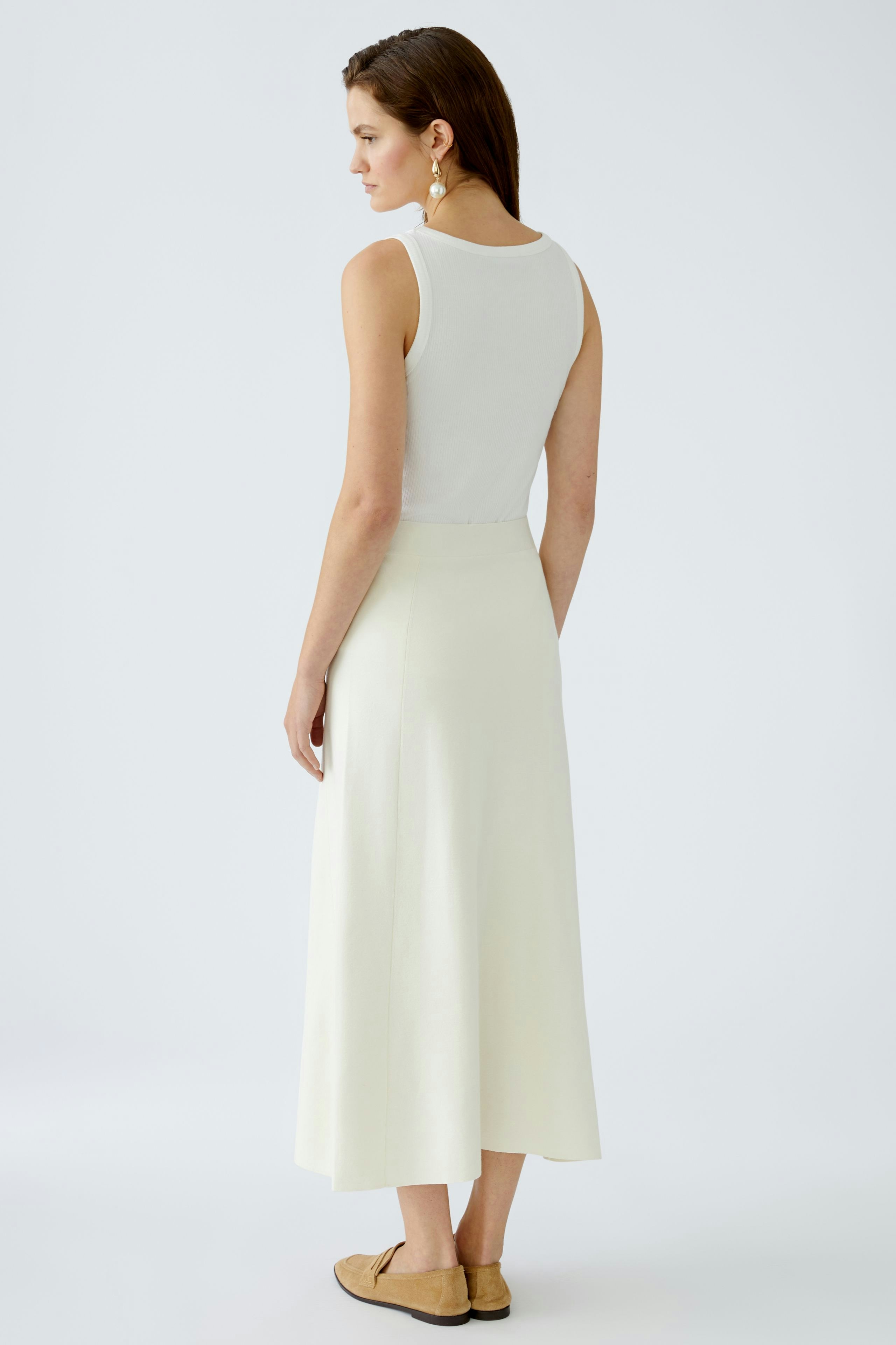 Elegant women's knit skirt: A woman in a flowing light yellow skirt, showcasing a chic and modern style.