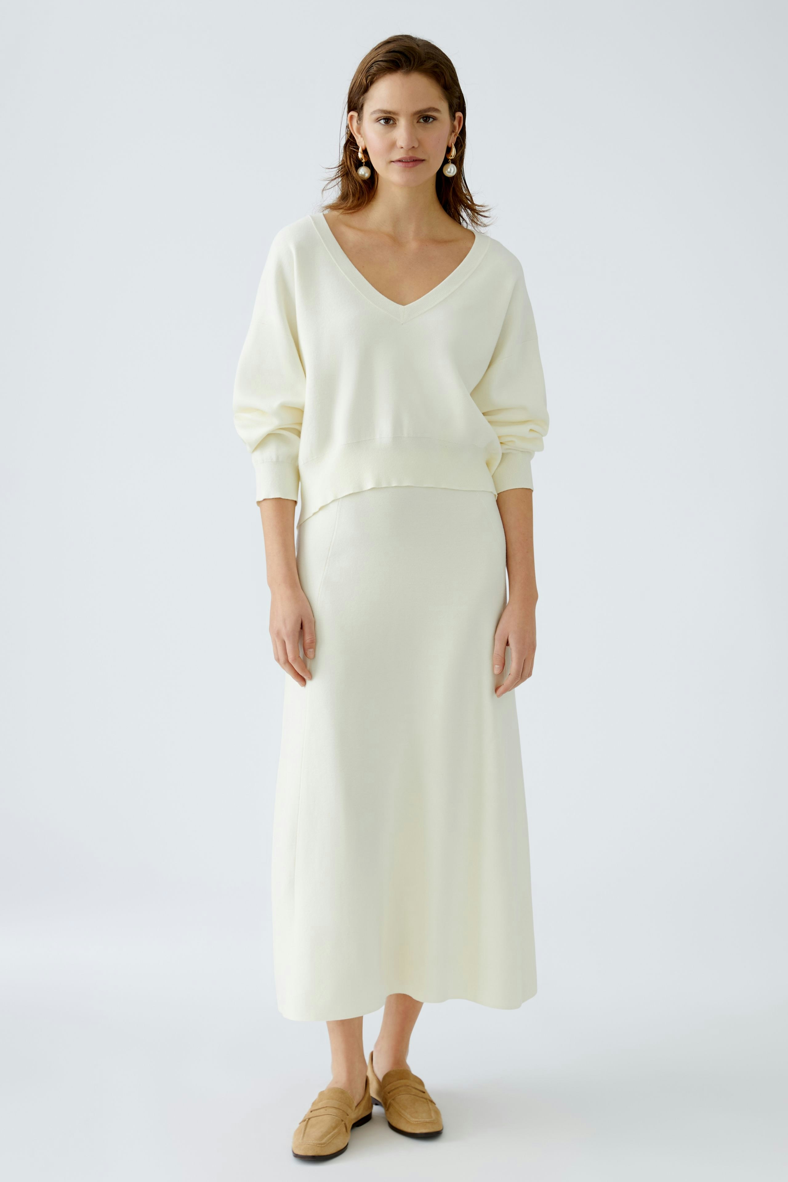 Elegant women's knitted skirt paired with a matching pullover, showcasing a chic, minimalist style.