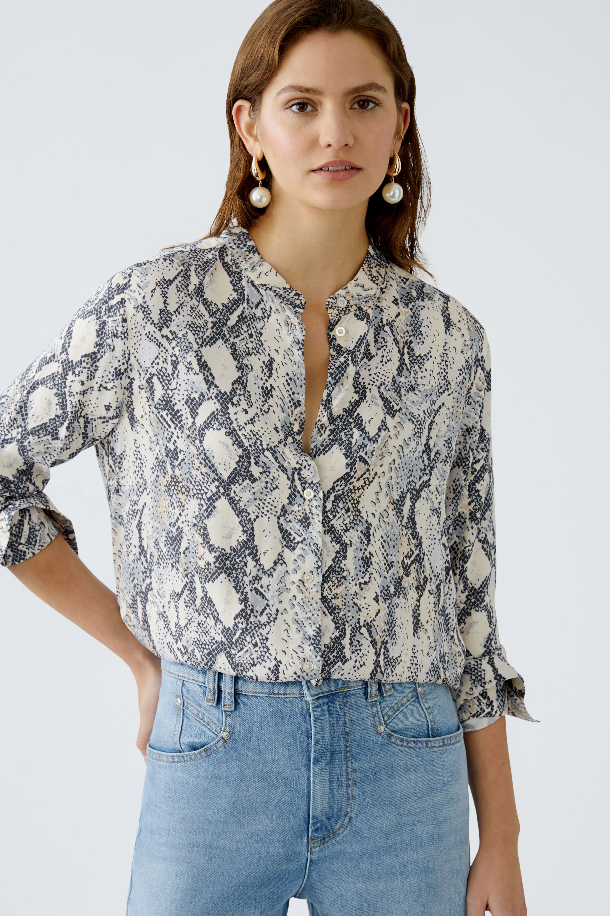 Elegante Damen-Bluse im Schlangenprint, lässig kombiniert mit Jeans, für einen modernen Look.