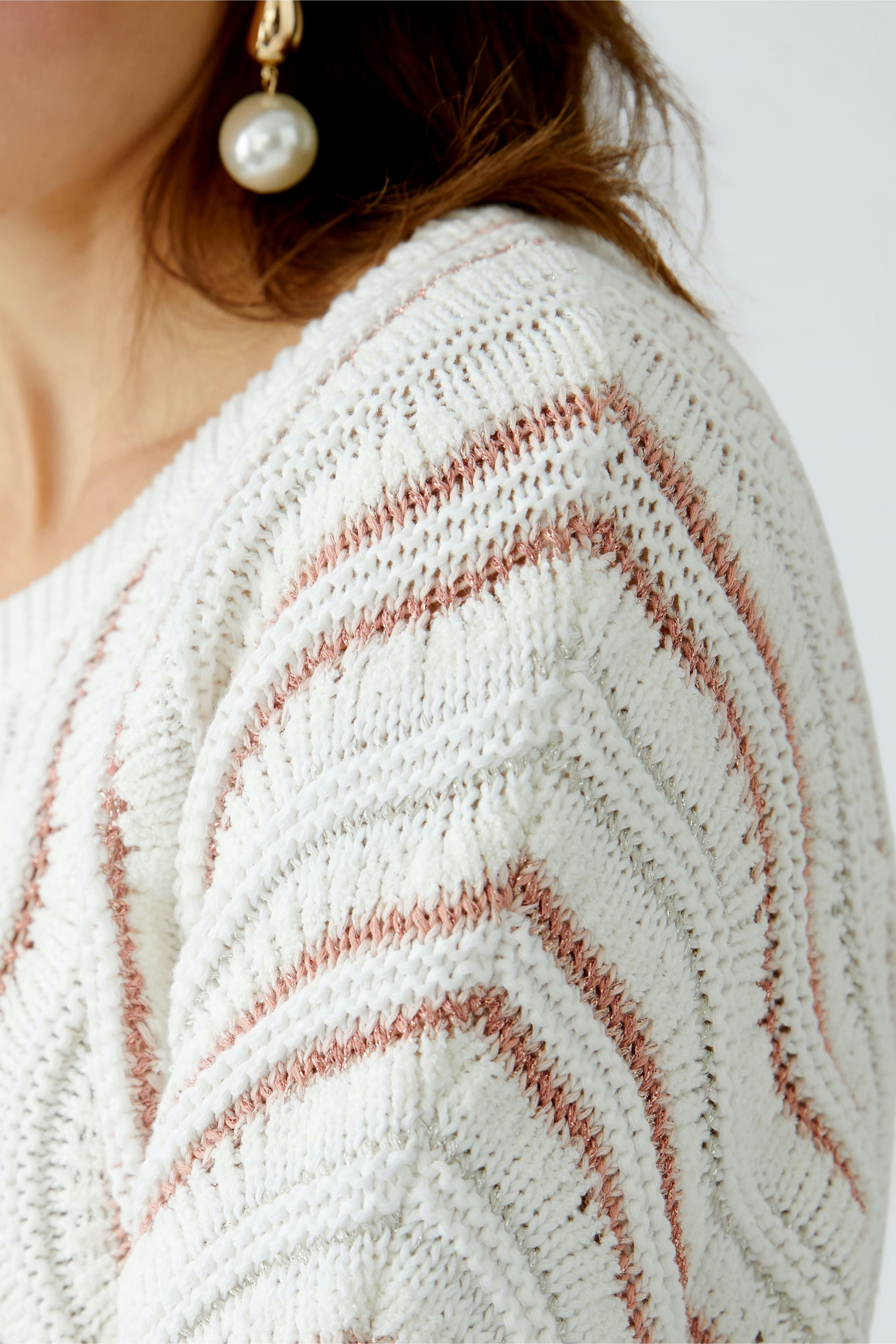 Stylish women's pullover with a textured design in soft white and subtle pink stripes.