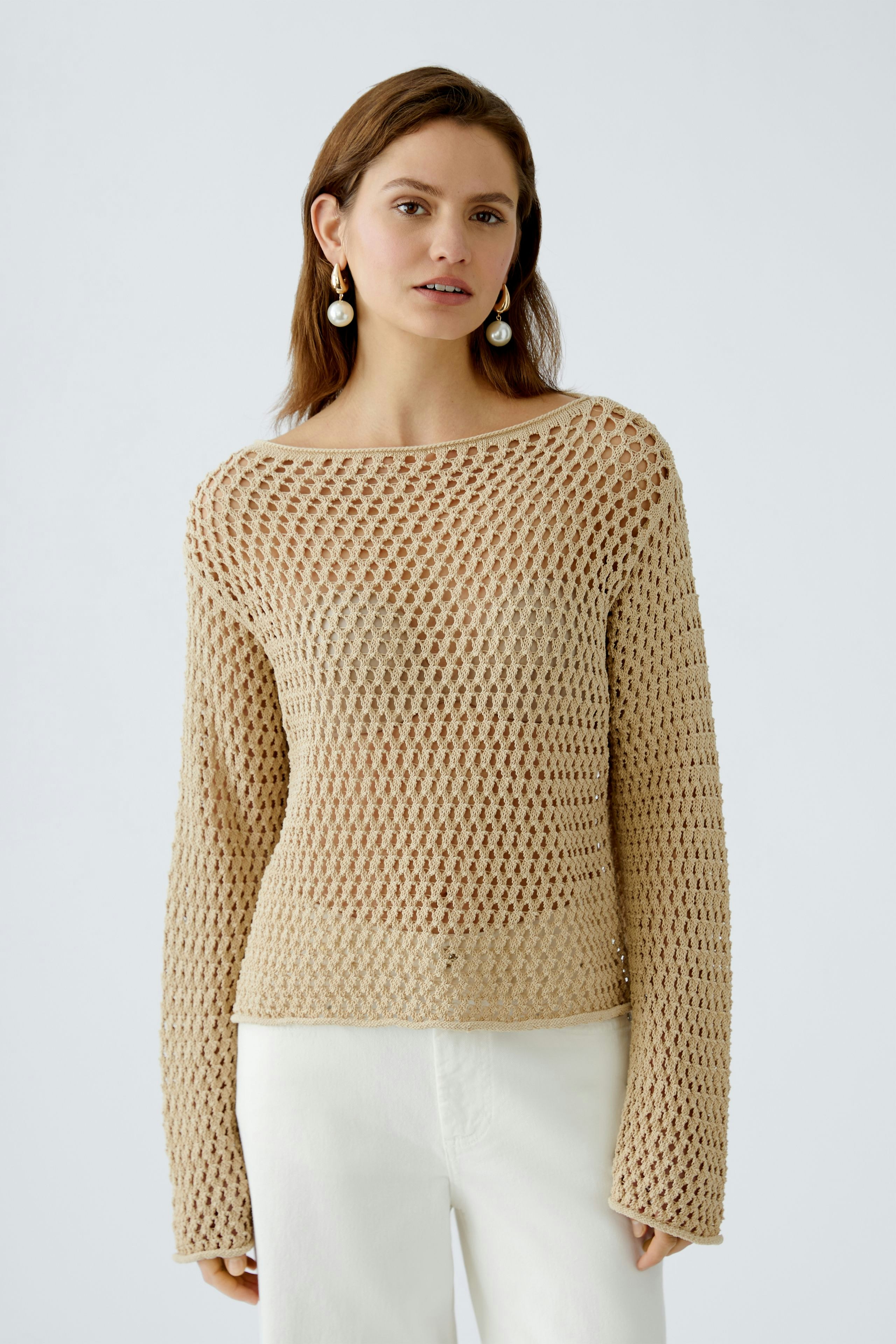 Damen-Pullover: Frau in beigem, luftigen Strickpullover mit weitem Schnitt und langen Ärmeln.