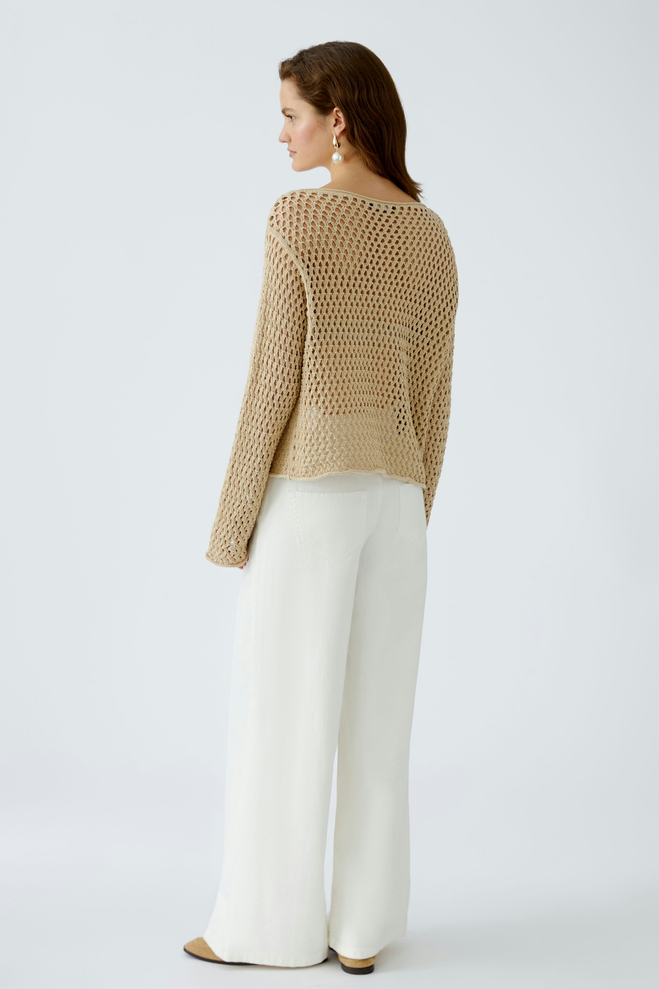 Damen-Pullover: Frau in beigem, luftigen Strickpullover mit weitem Schnitt und lässigen Hosen.