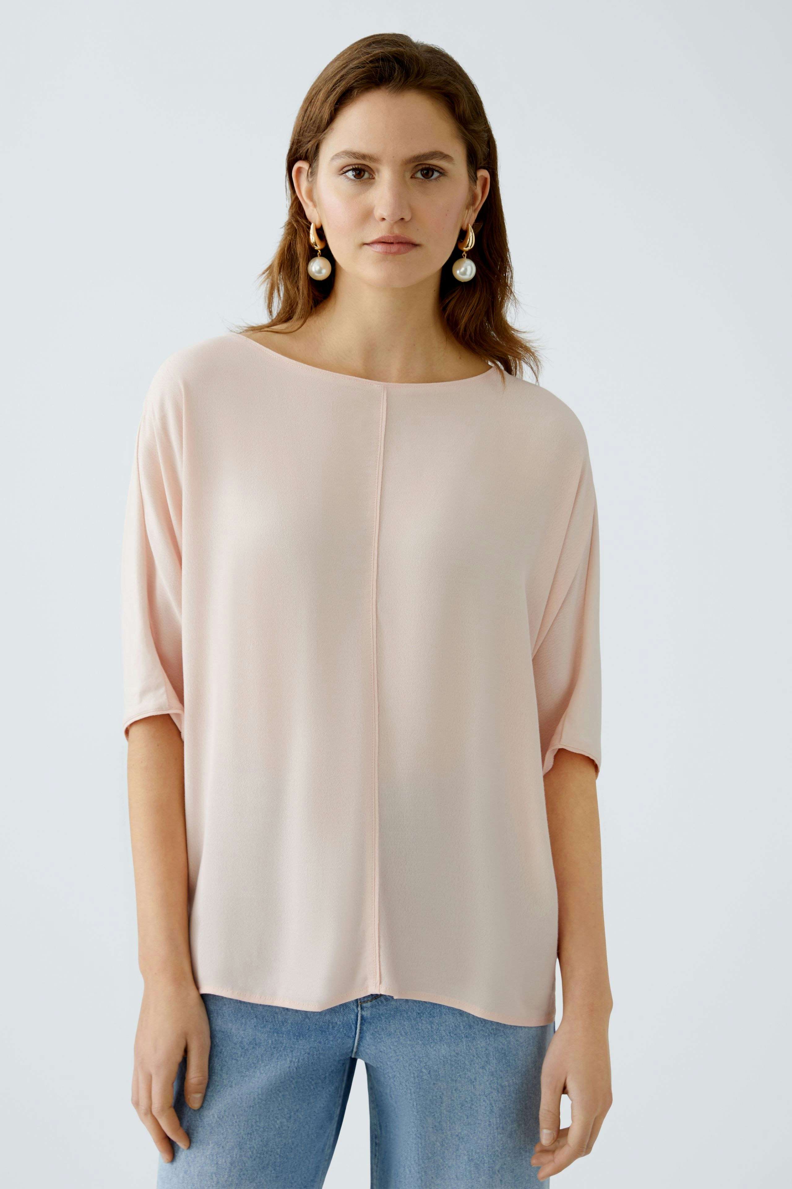 Leichtes Blusenshirt in zartem Rosa: Frau trägt ein lässiges, elegantes Oberteil.