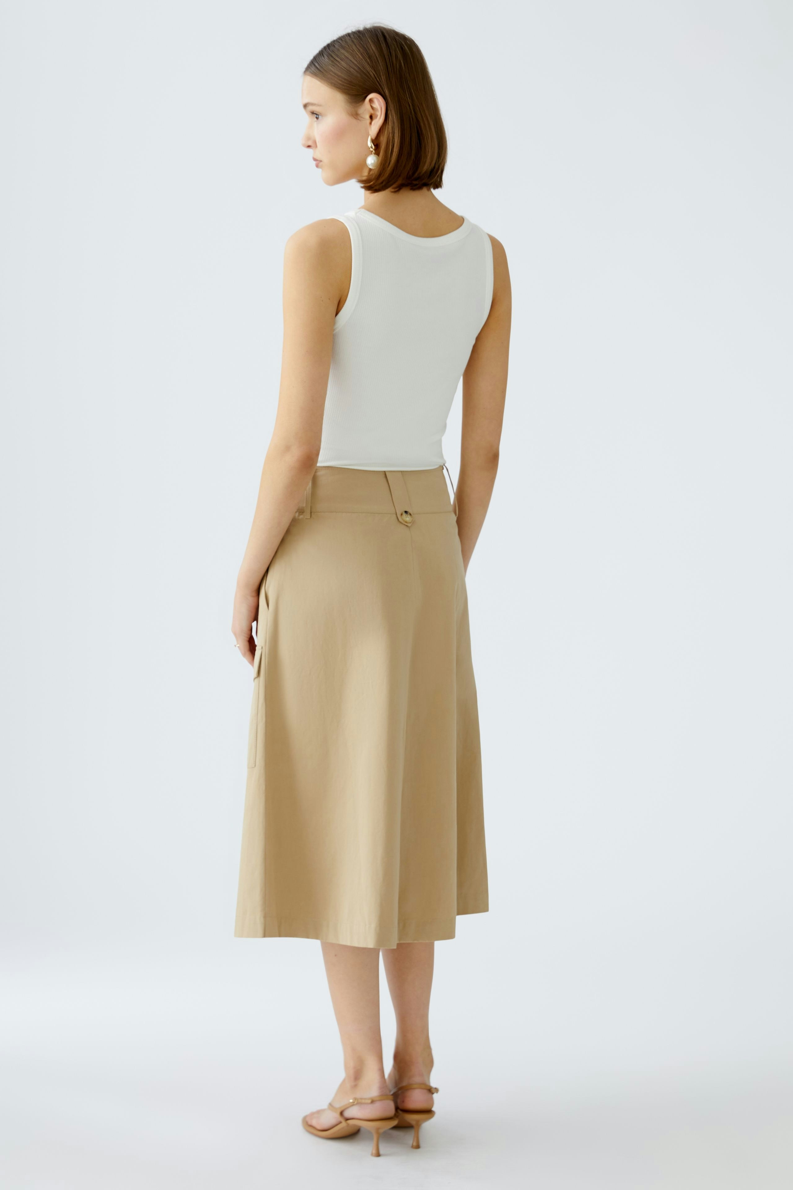 Elegant wrap skirt: A woman in a beige wrap skirt, showcasing a stylish and versatile design.