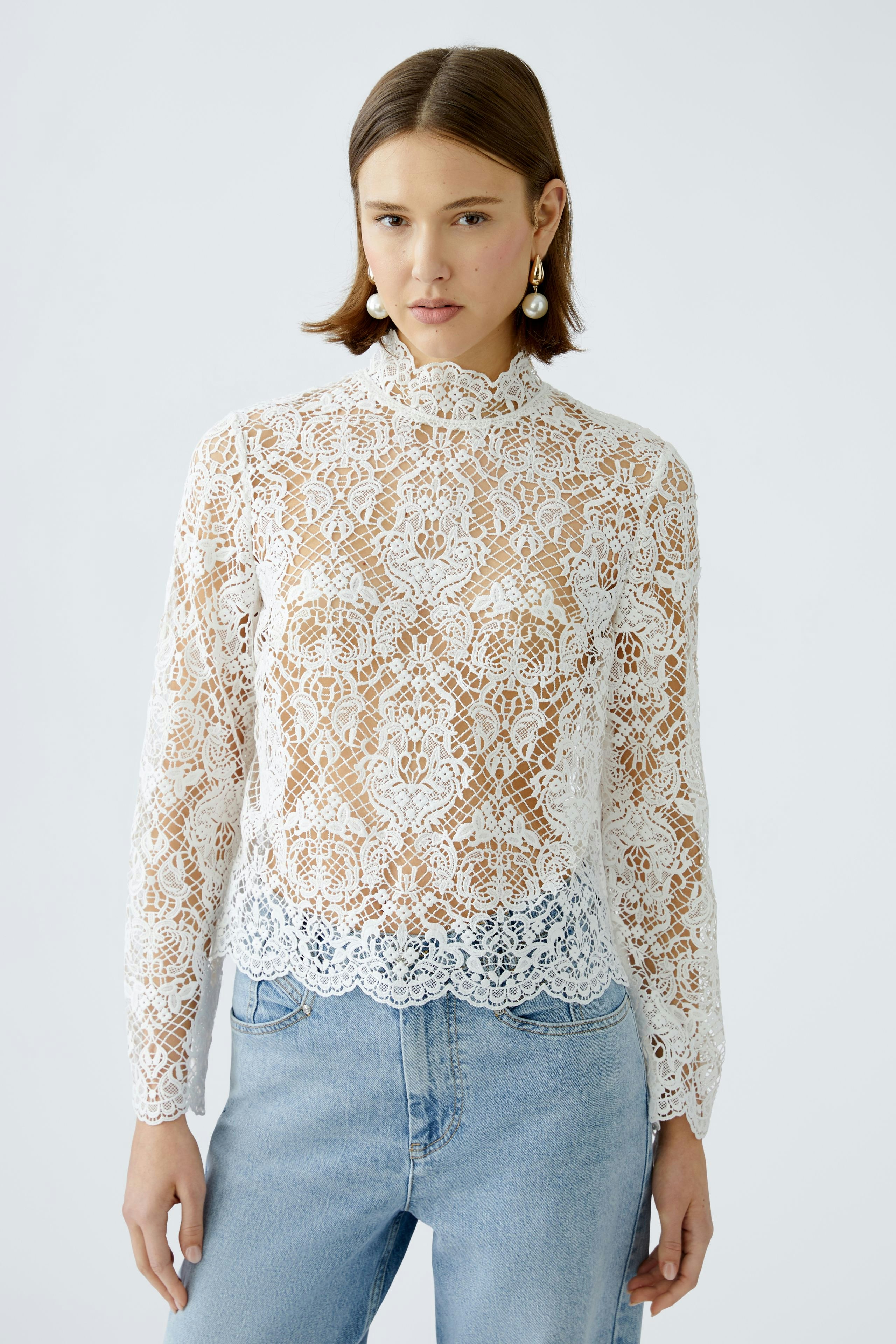 Elegant women's blouse: A woman in a white lace blouse with long sleeves and a high neckline.