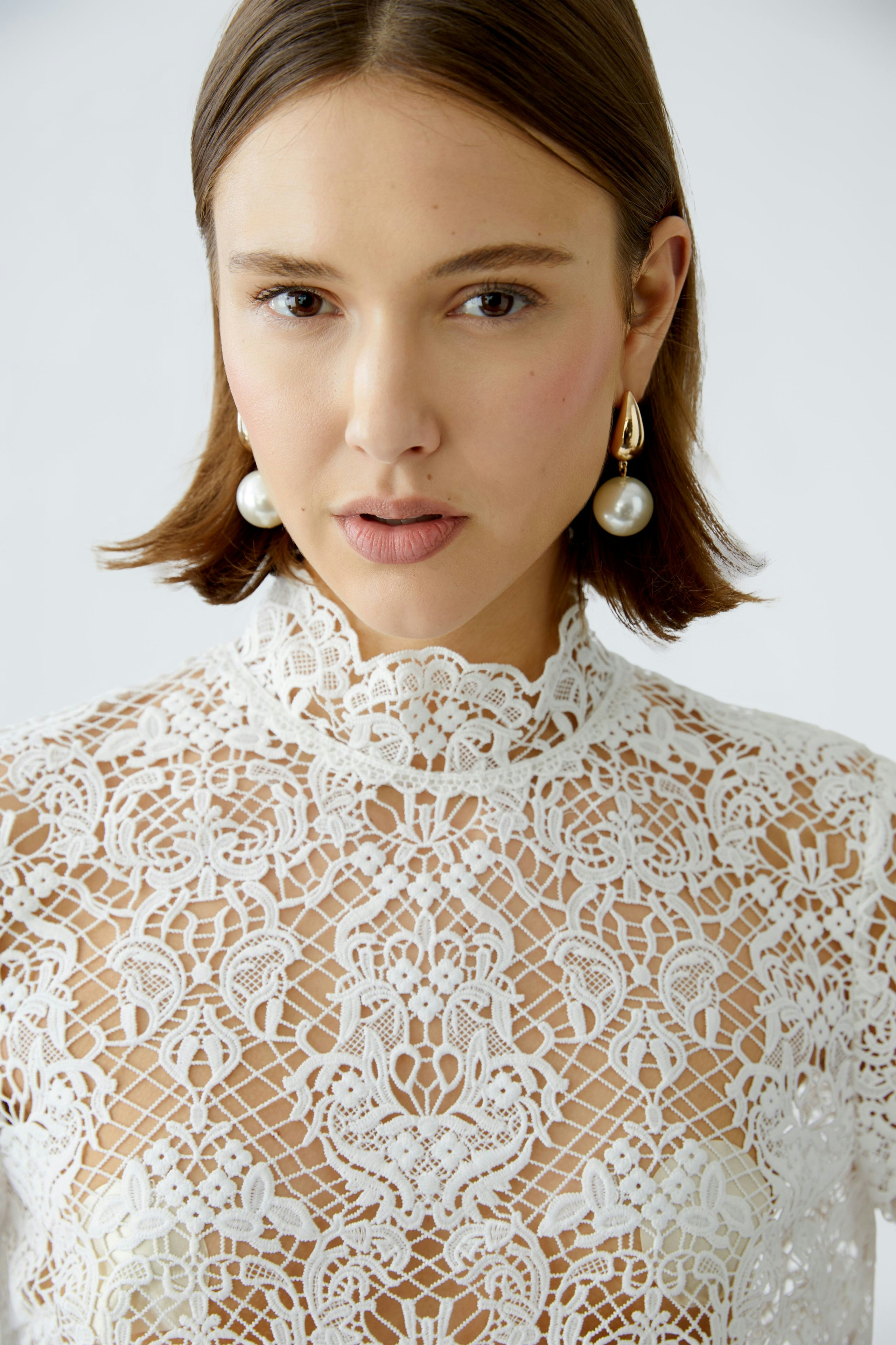 Elegant women's blouse with intricate lace detailing, showcasing a sophisticated style.