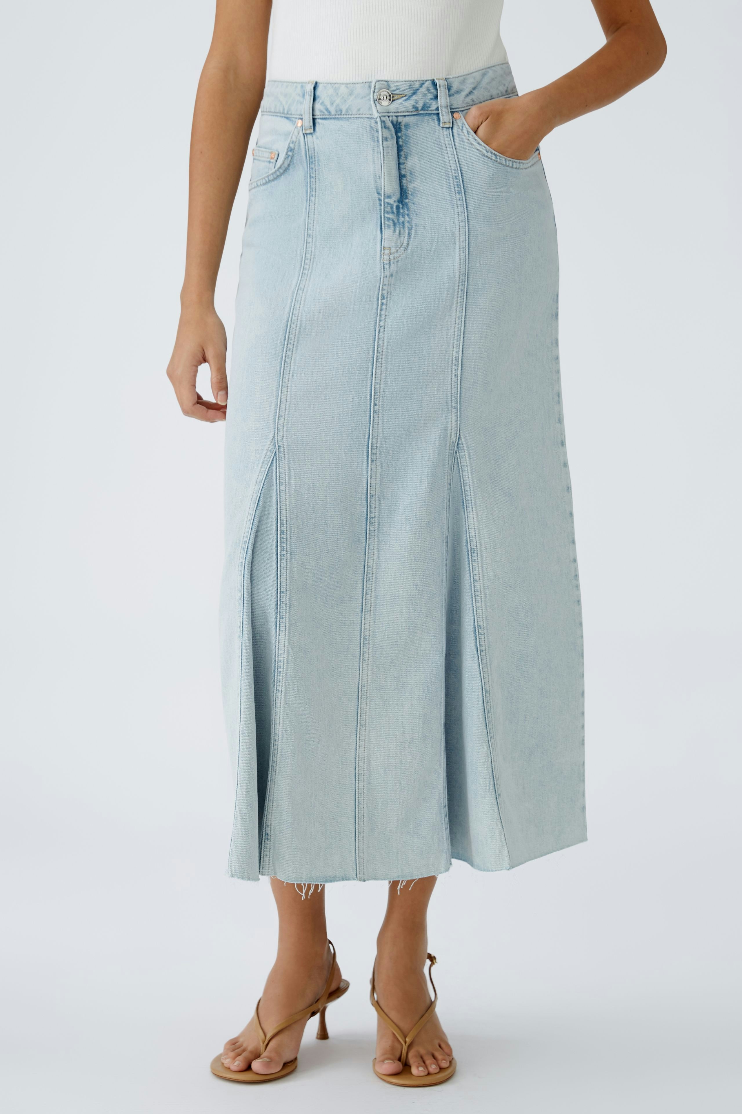 Stylish denim skirt: A woman in a light blue long skirt with pockets, perfect for casual outings.