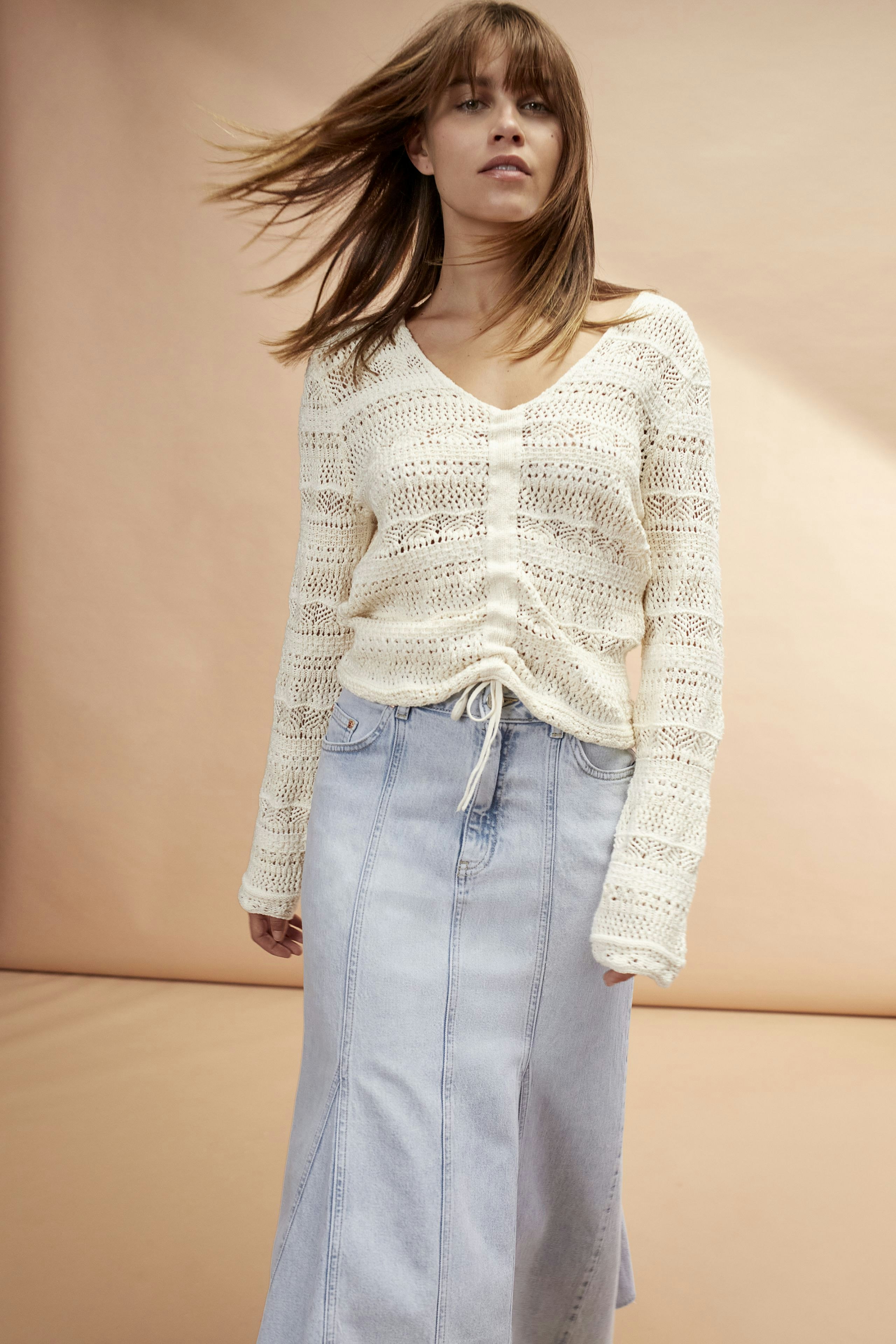 Stylish denim skirt: A woman in a light blue long denim skirt paired with a casual pullover.