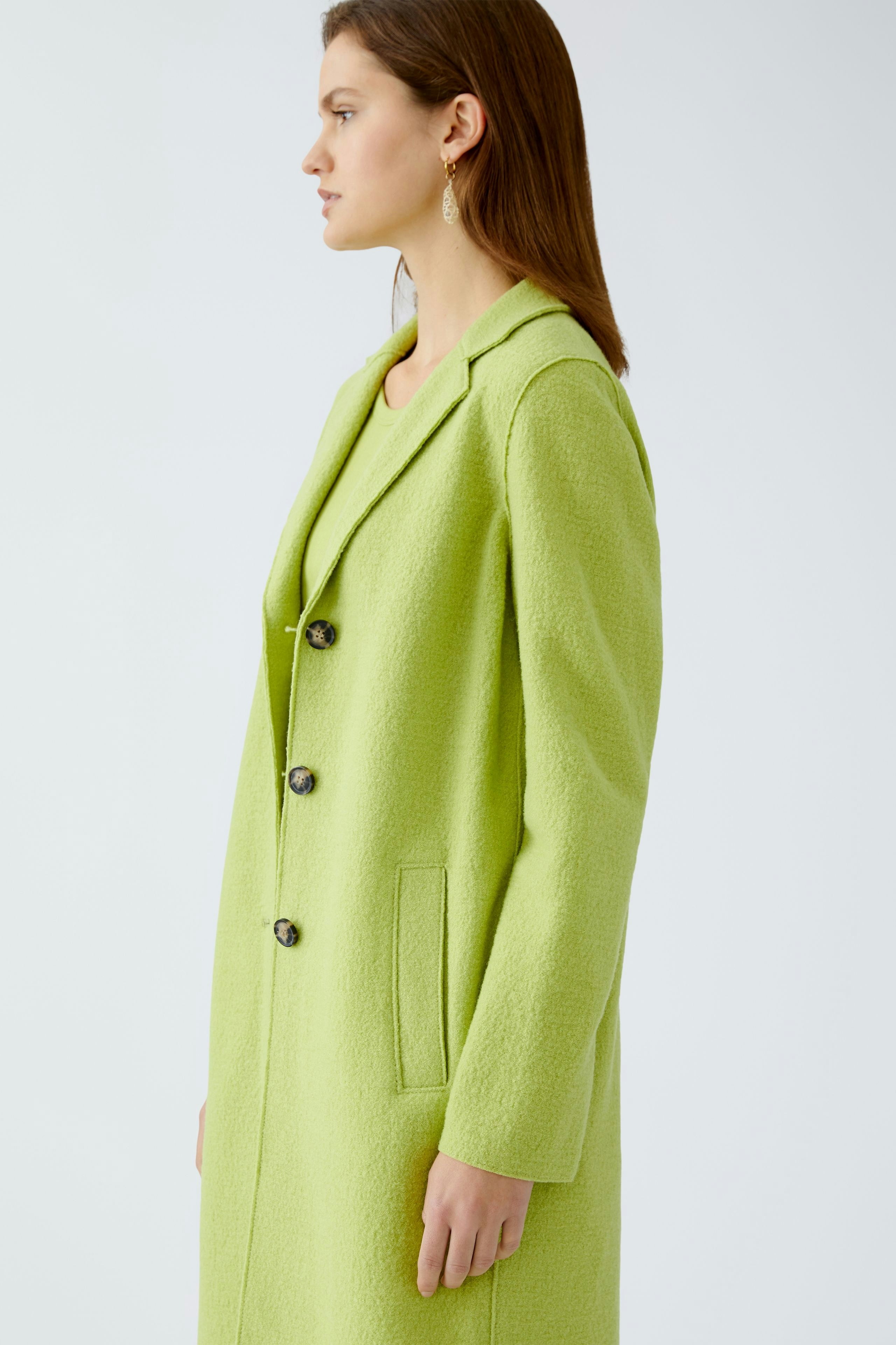 Stylish women's wool coat in vibrant green, featuring a tailored fit and elegant buttons.