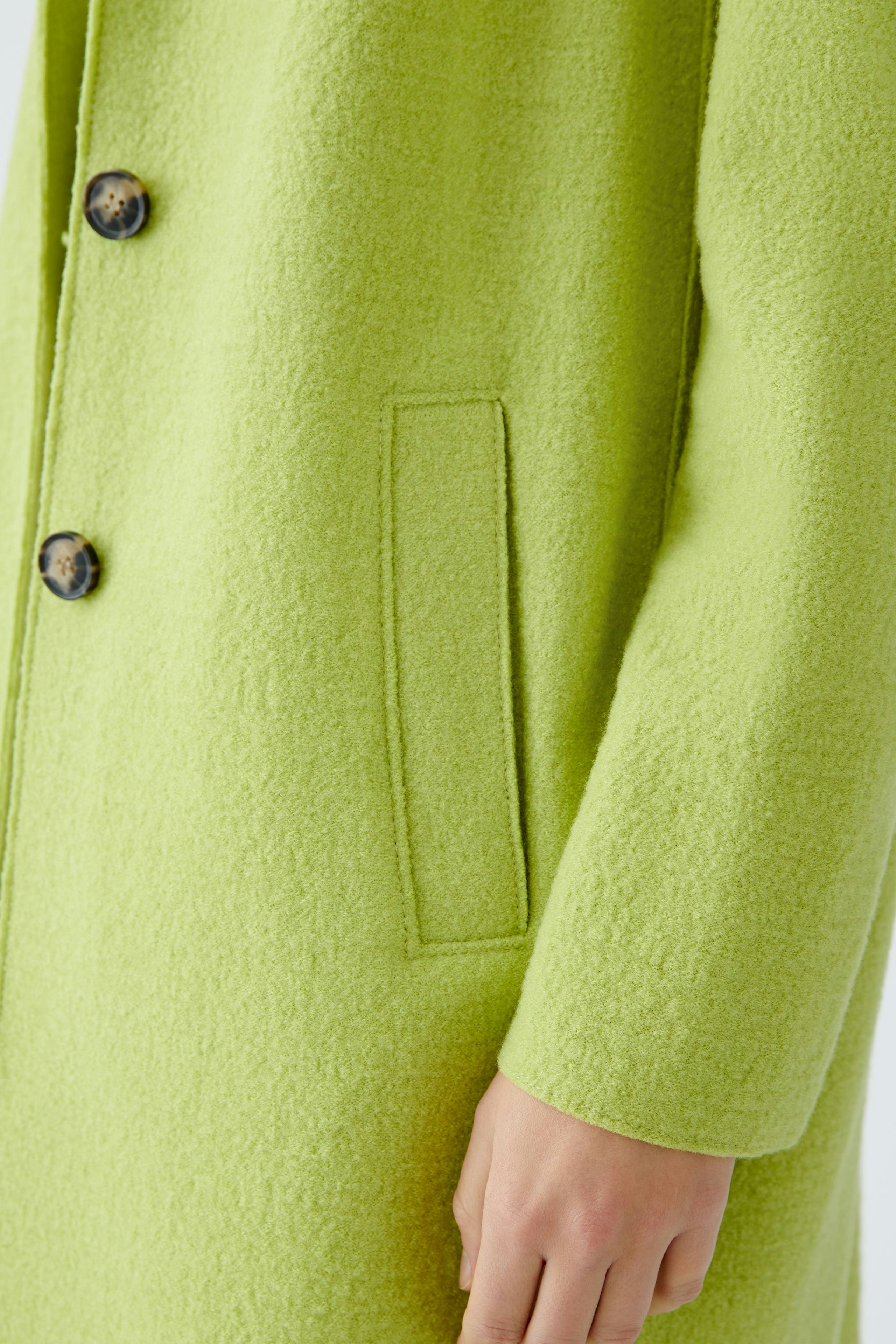 Stylish women's wool coat in vibrant green with button closure and side pockets.