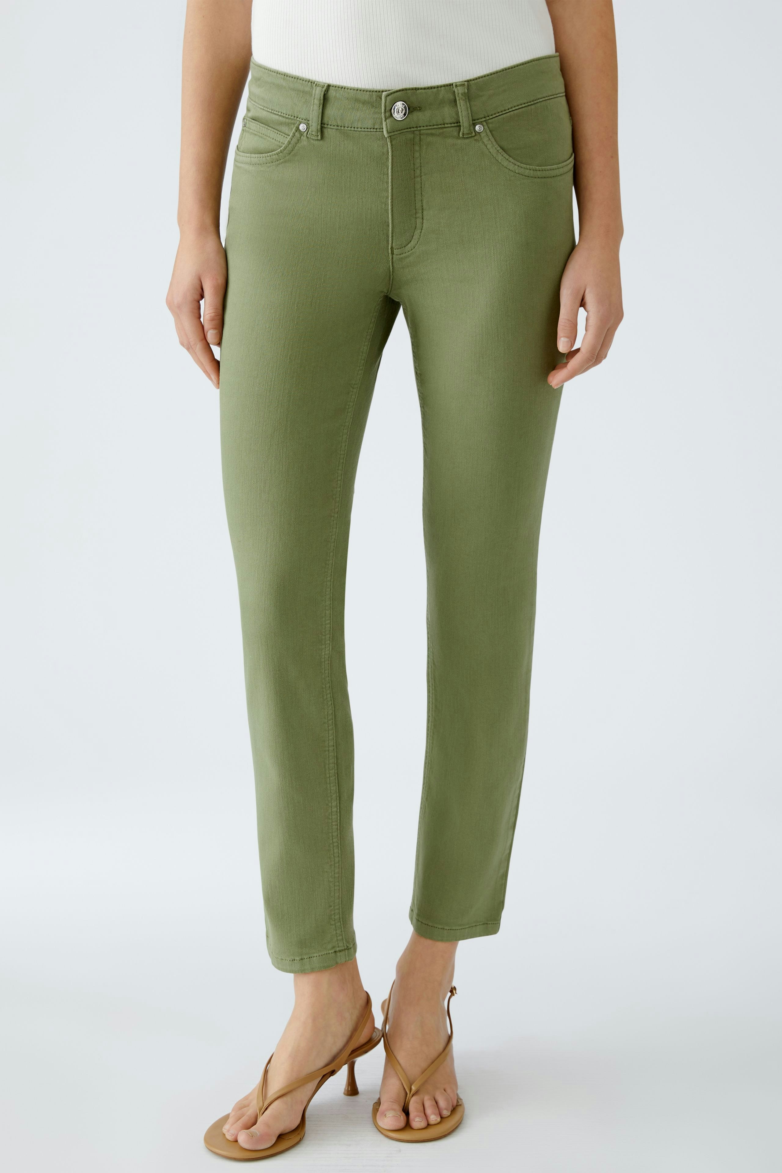 Moderne Jeggings: Frau in olivgrünen Jeggings mit schmalem Schnitt und lässigen Sandalen.