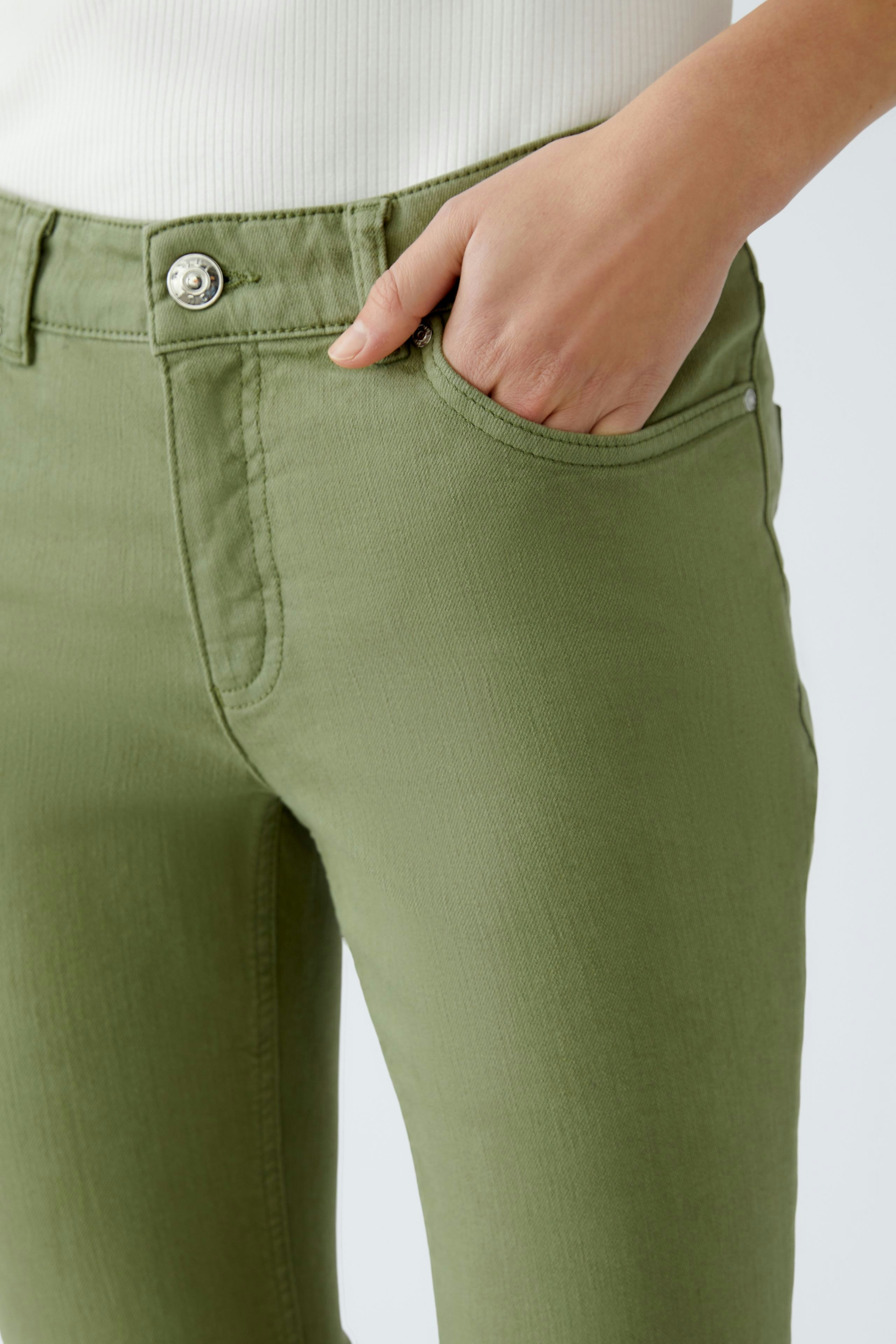 Moderne Jeggings: Frau trägt grüne Jeggings mit seitlichen Taschen und lässigem Look.