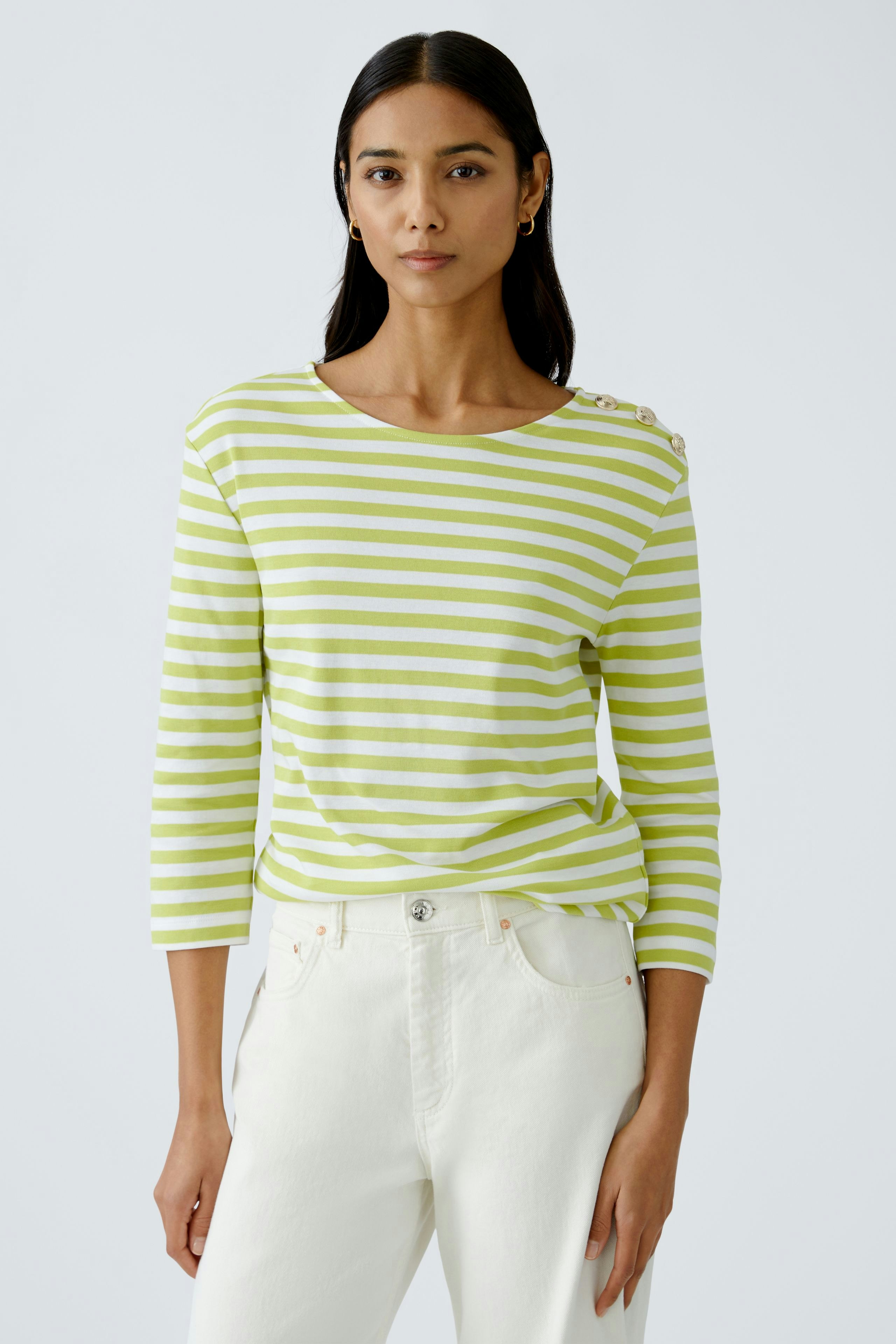 Stylish long-sleeve shirt: Confident woman in a striped pullover with button details.