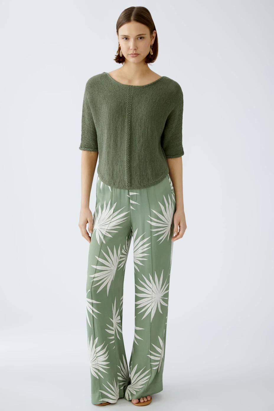 Stylish women's trousers: Flowing green pants with white leaf patterns, perfect for a casual look.