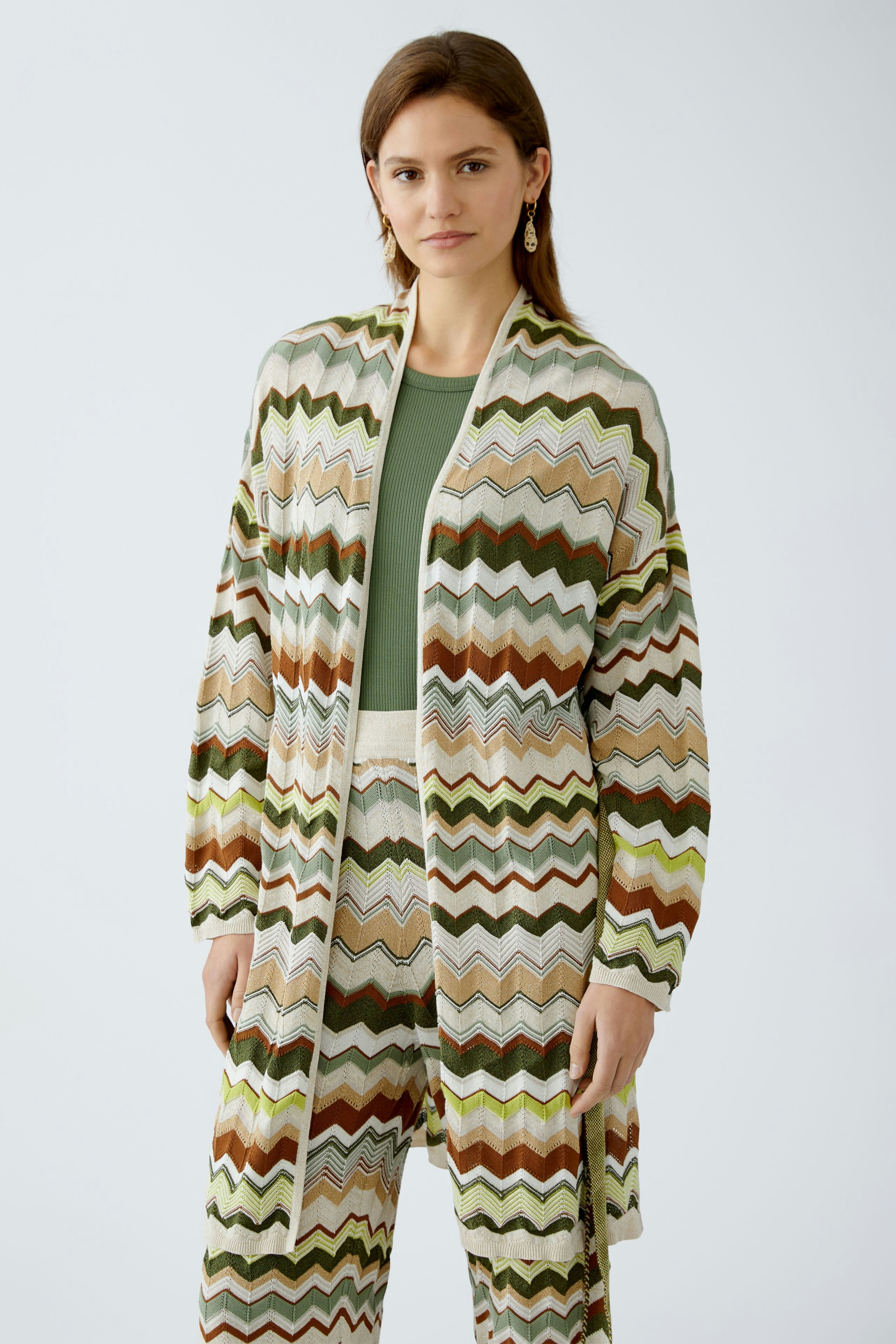 Stylish women's cardigan: A woman in a colorful zigzag-patterned knit cardigan, exuding a relaxed vibe.
