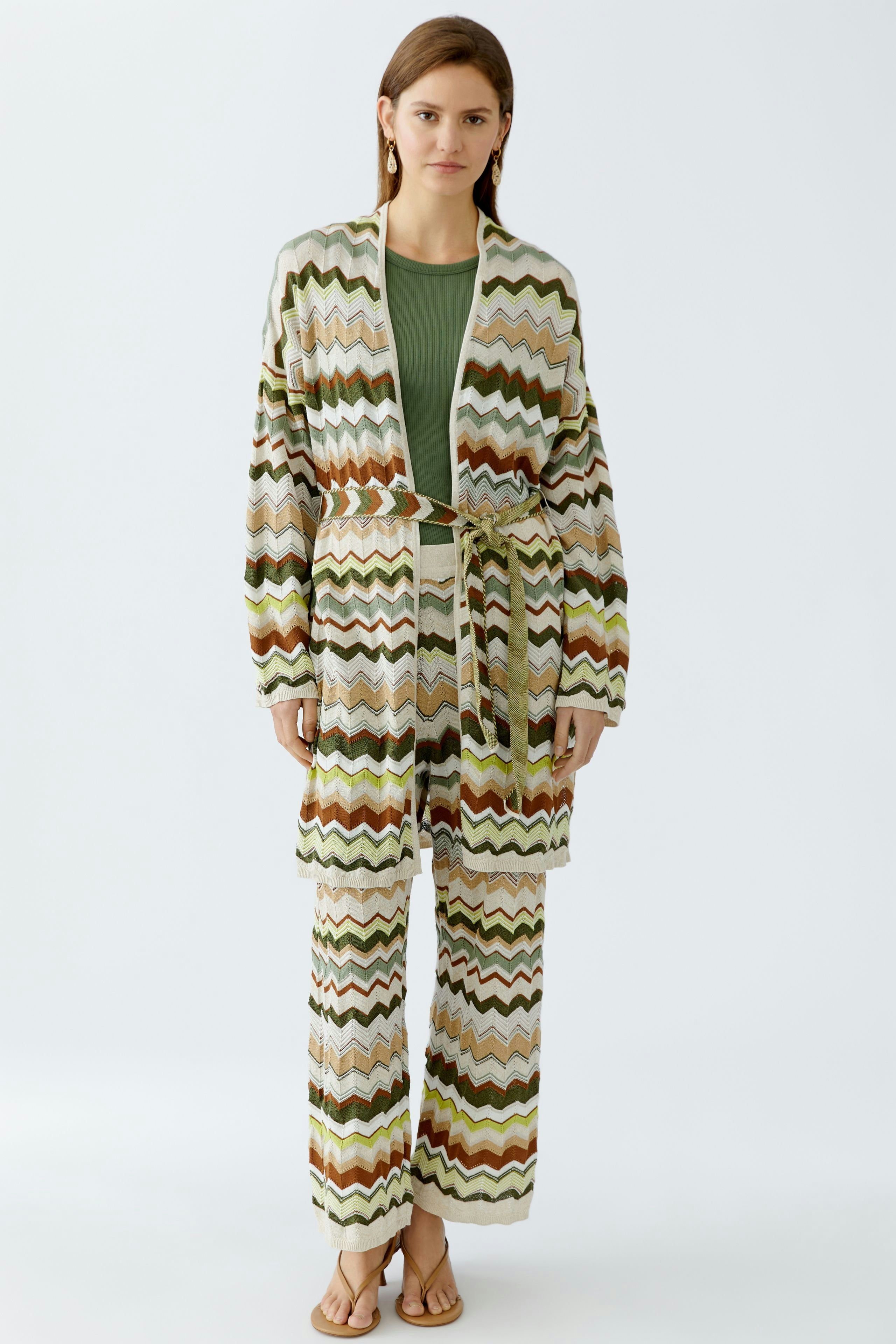 Stylish women's cardigan: A woman in a colorful zigzag-patterned knit cardigan, paired with matching pants.