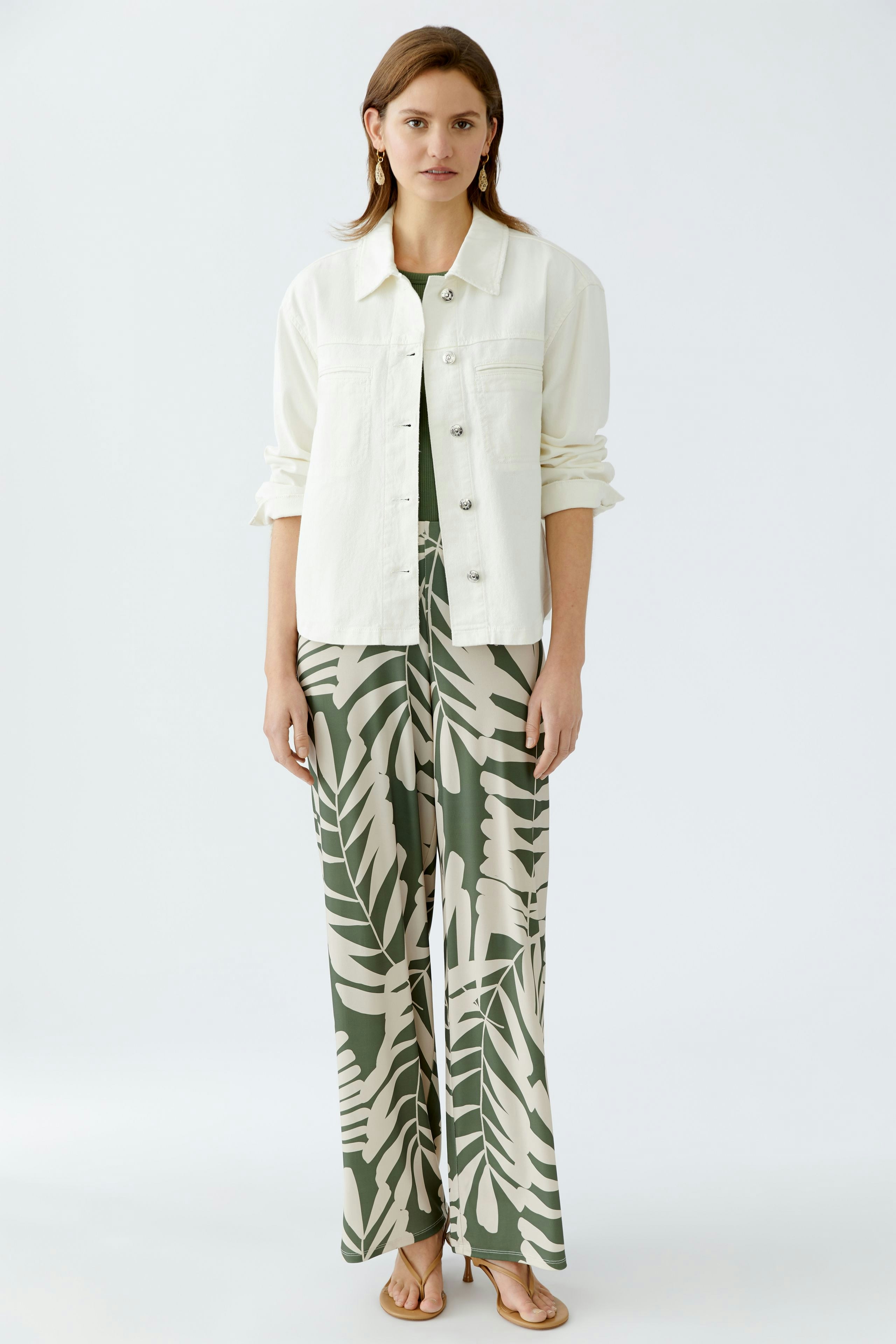 Stylish women's denim jacket: A woman in a white jacket paired with patterned wide-leg pants.