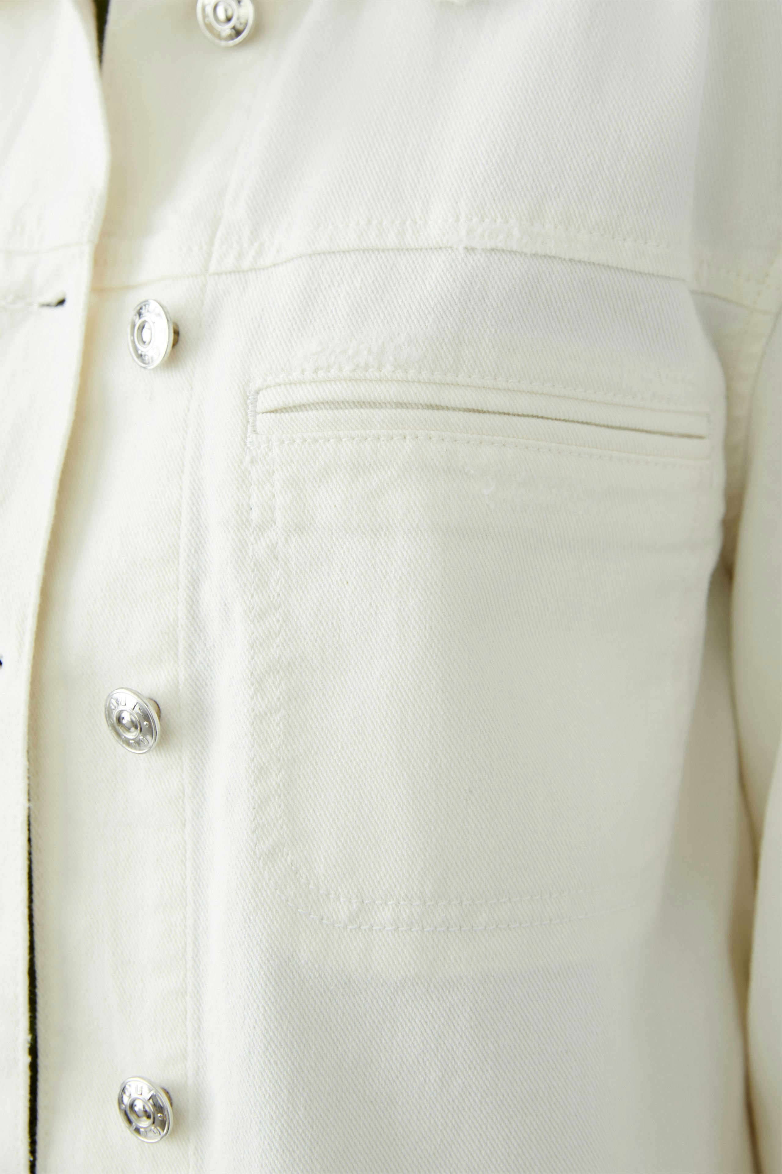 Stylish women's denim jacket in light color with classic button closure and chest pocket.