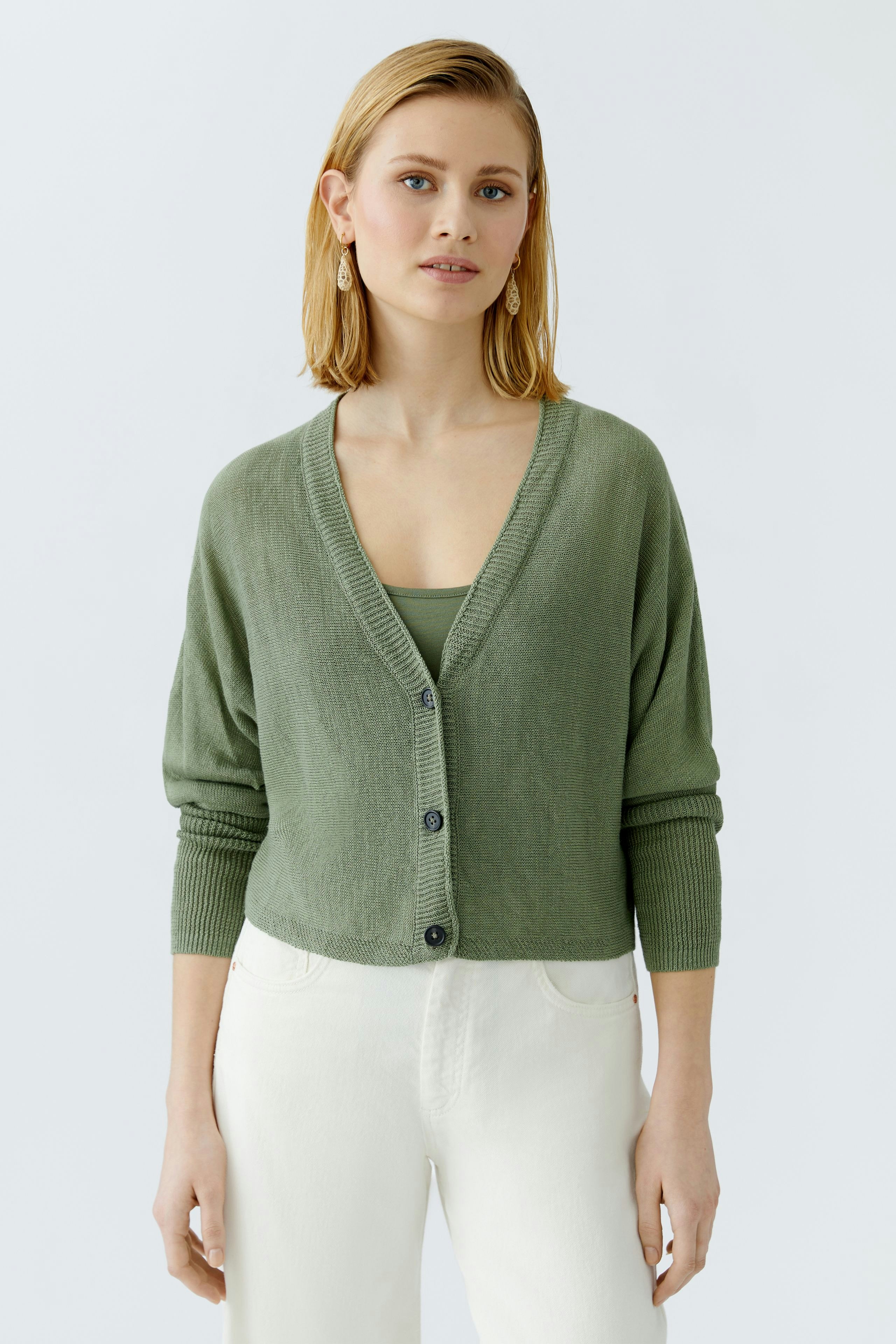 Damen-Strickjacke in sanftem Olivgrün, lässig offen getragen, ideal für jeden Anlass.