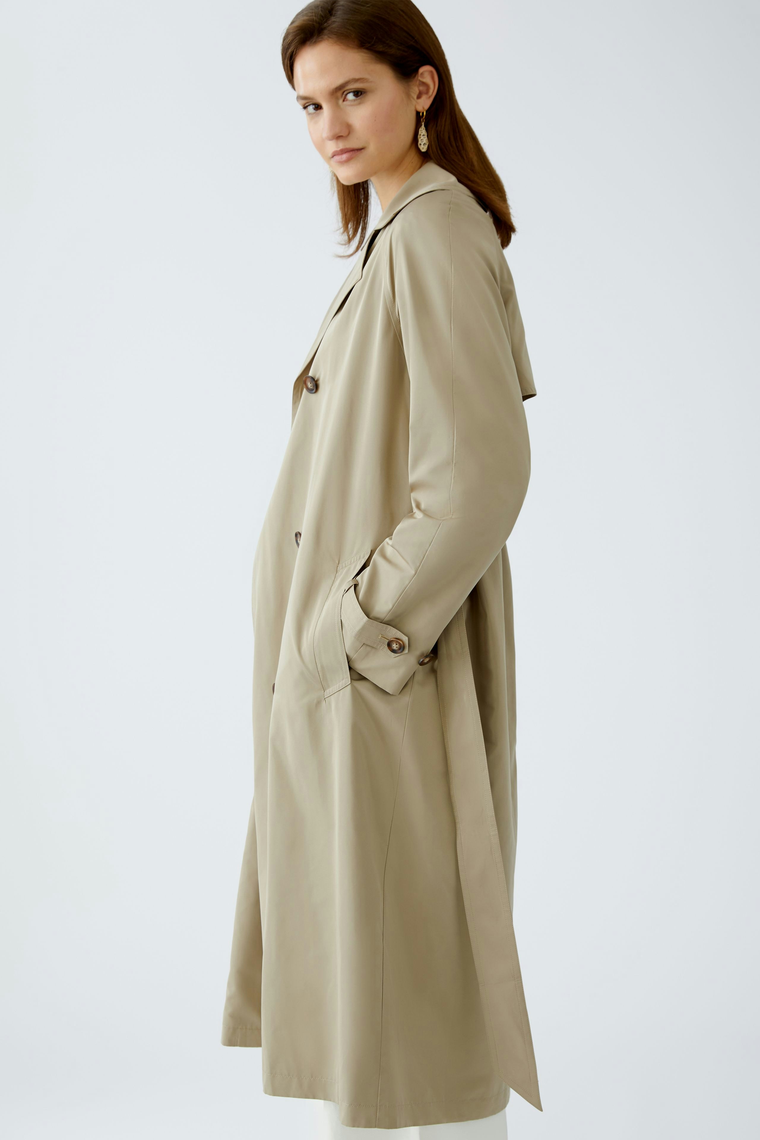 Stylish trench coat: A woman in a beige trench coat with a classic design, perfect for any occasion.