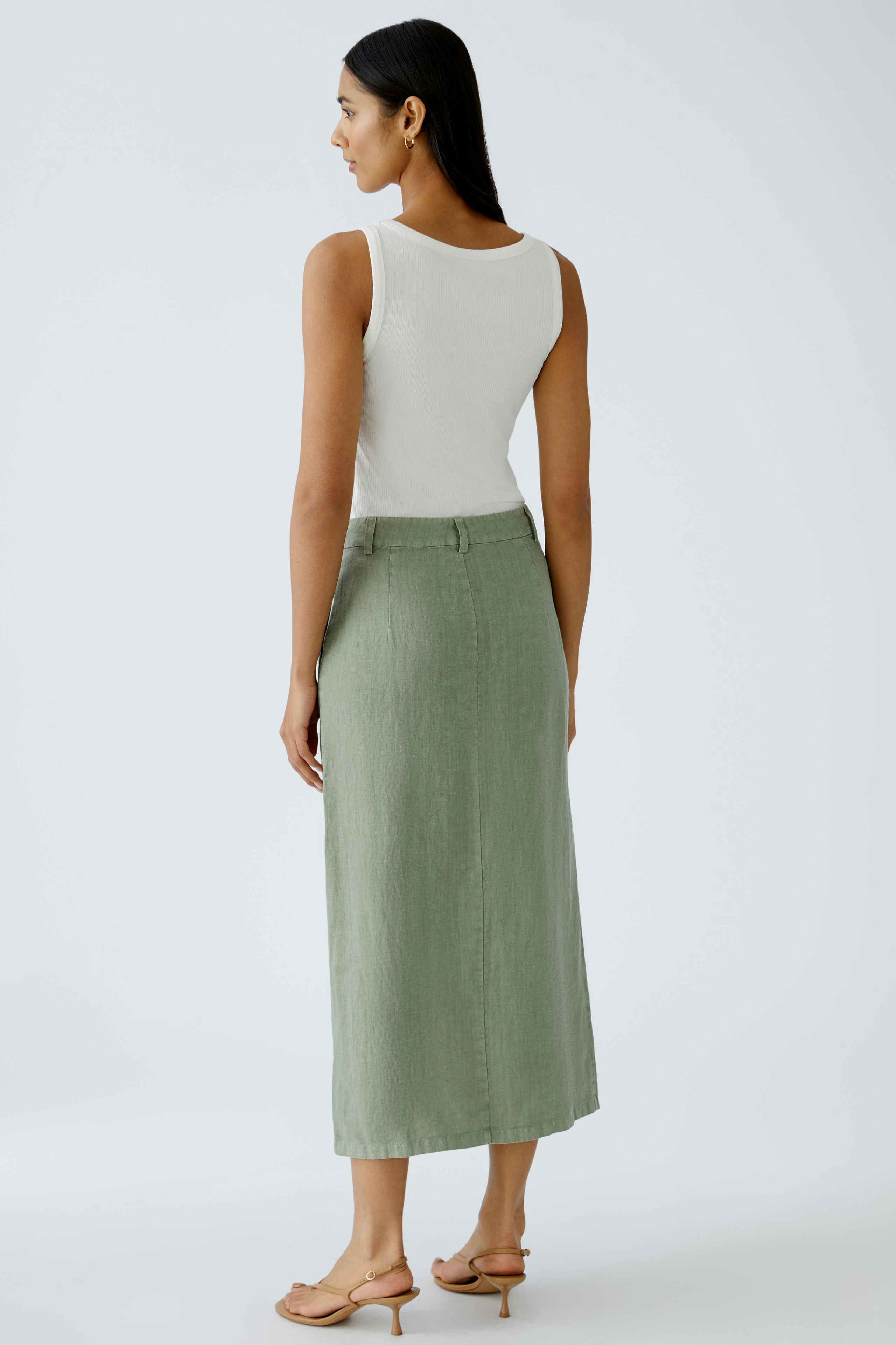 Elegant midi skirt: Woman in a green linen skirt, showcasing a stylish and versatile design.
