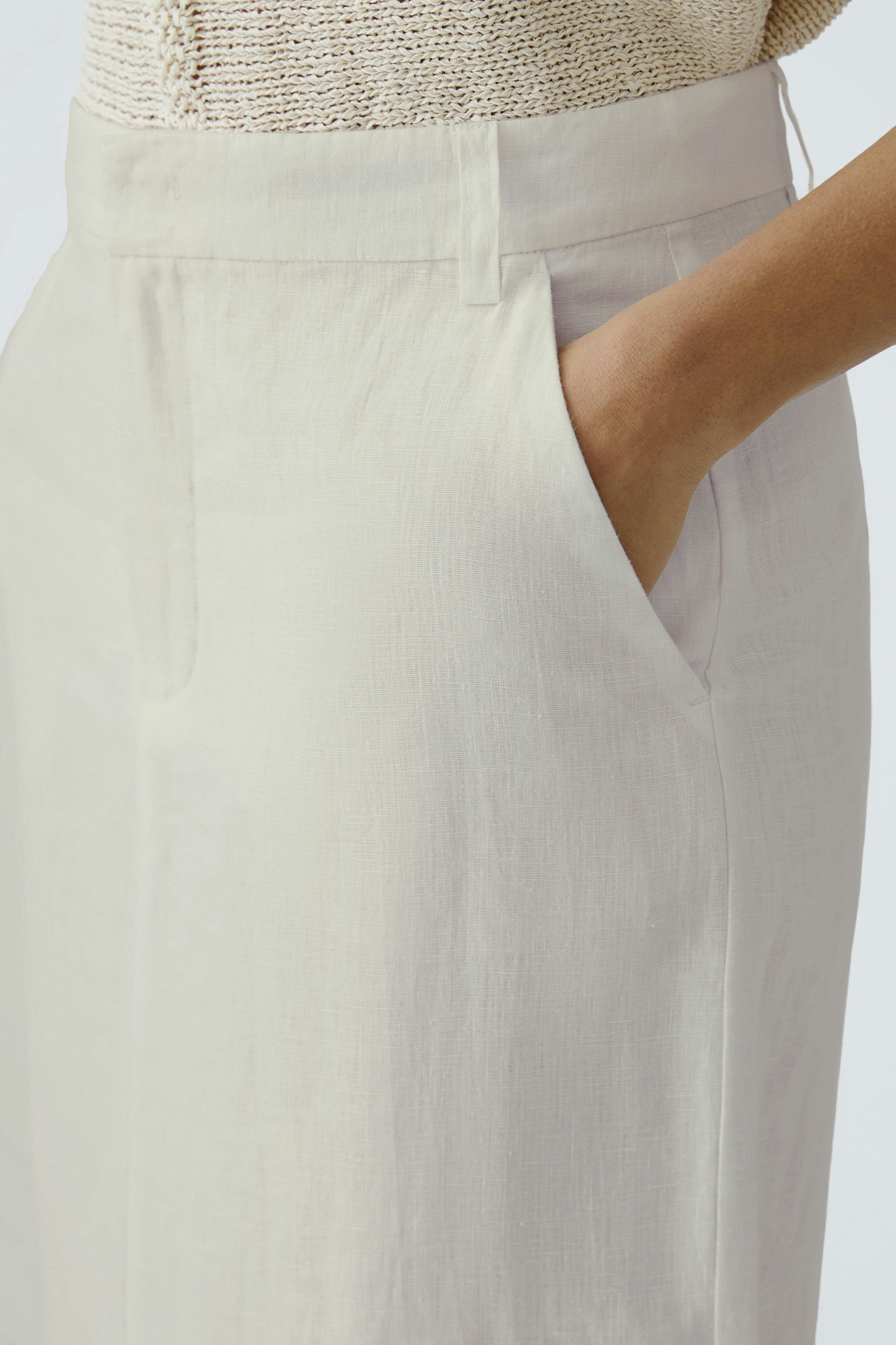 Eleganter Midirock: Frau mit bequemen Taschen und fließendem Stoff, ideal für den Alltag.