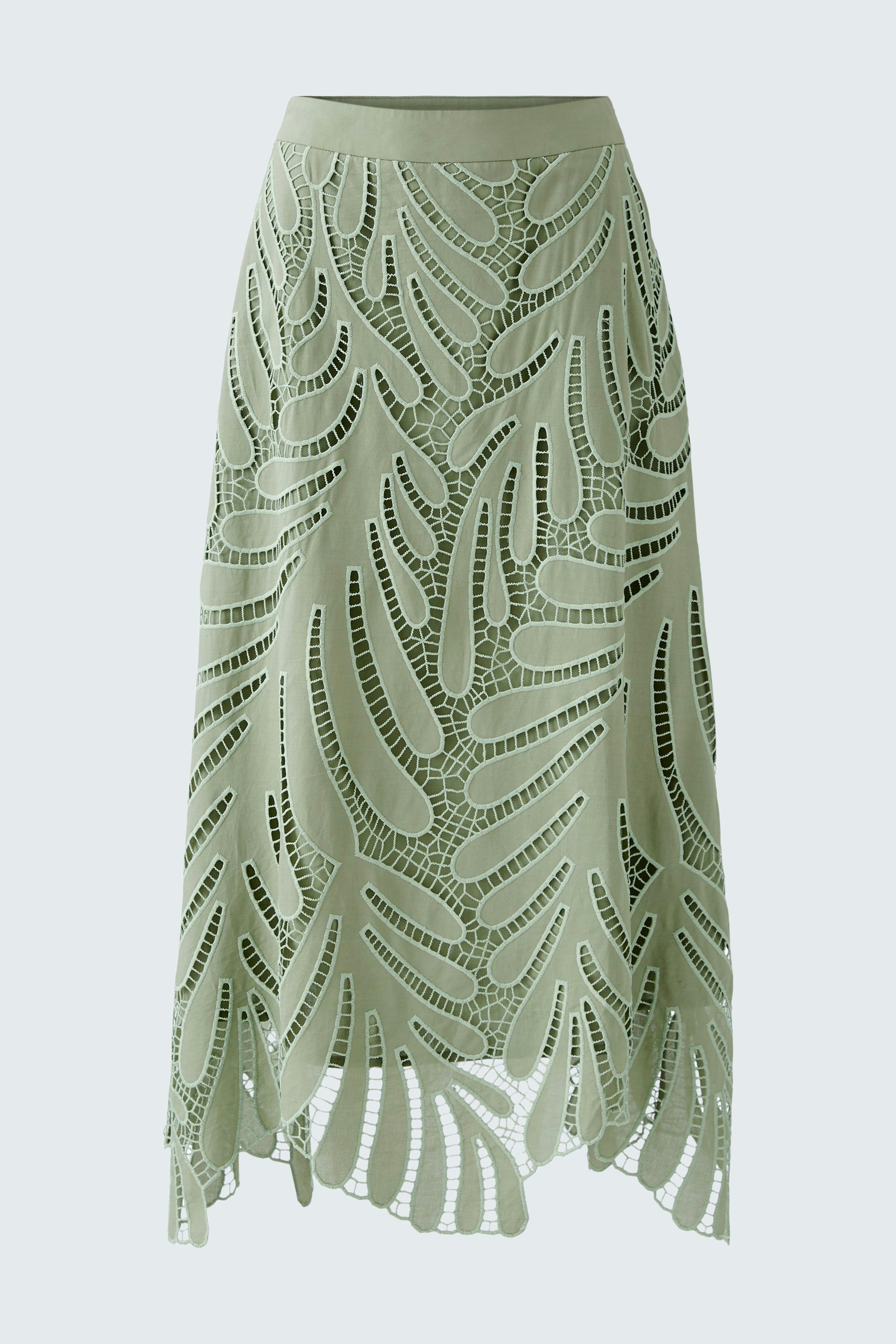 Elegant A-line skirt: A woman in a light green skirt with intricate cut-out patterns, exuding style.