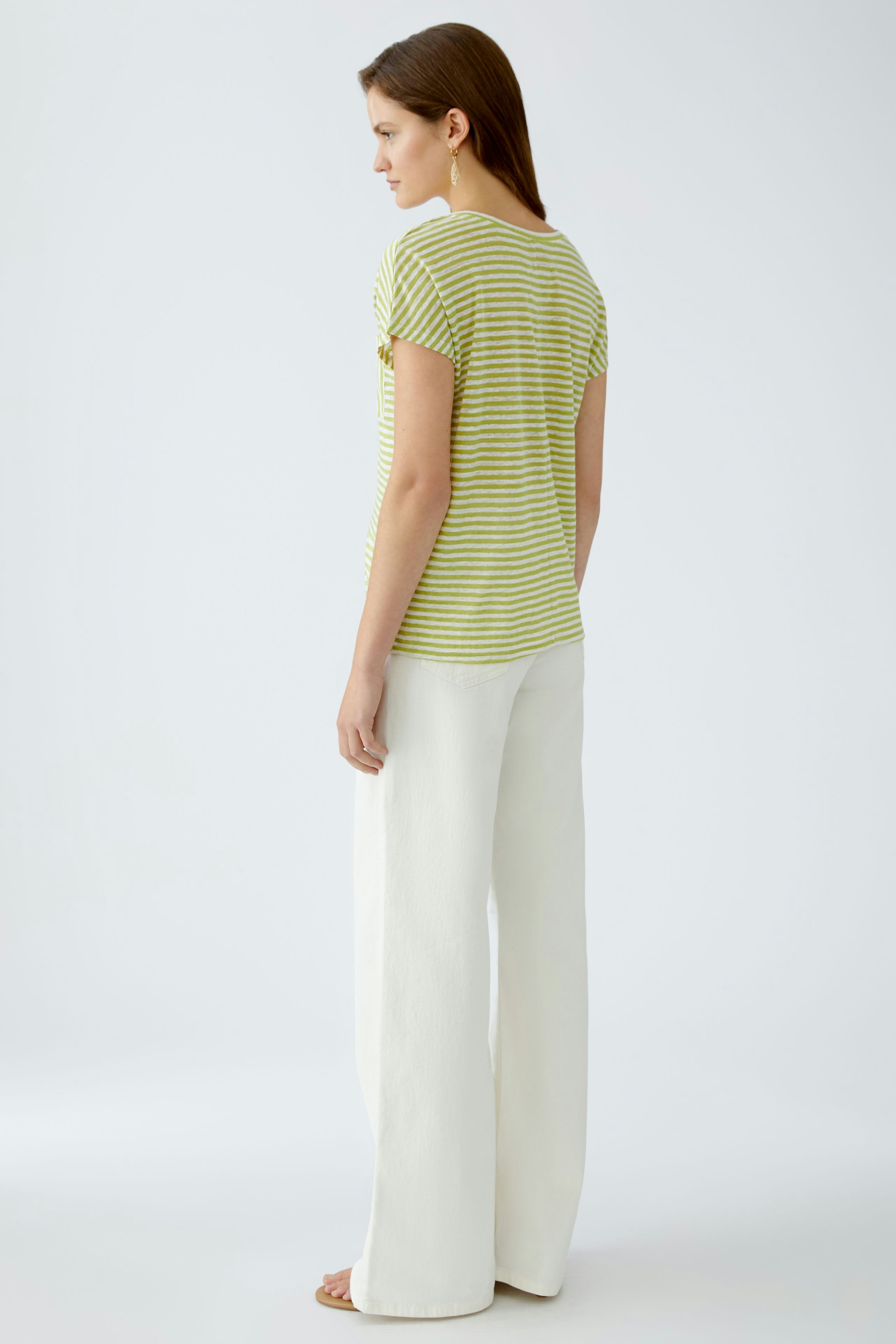 Damen-T-Shirt: Frau in gestreiftem, gelb-weißen Shirt mit lässigem Schnitt und weiten Hosen.