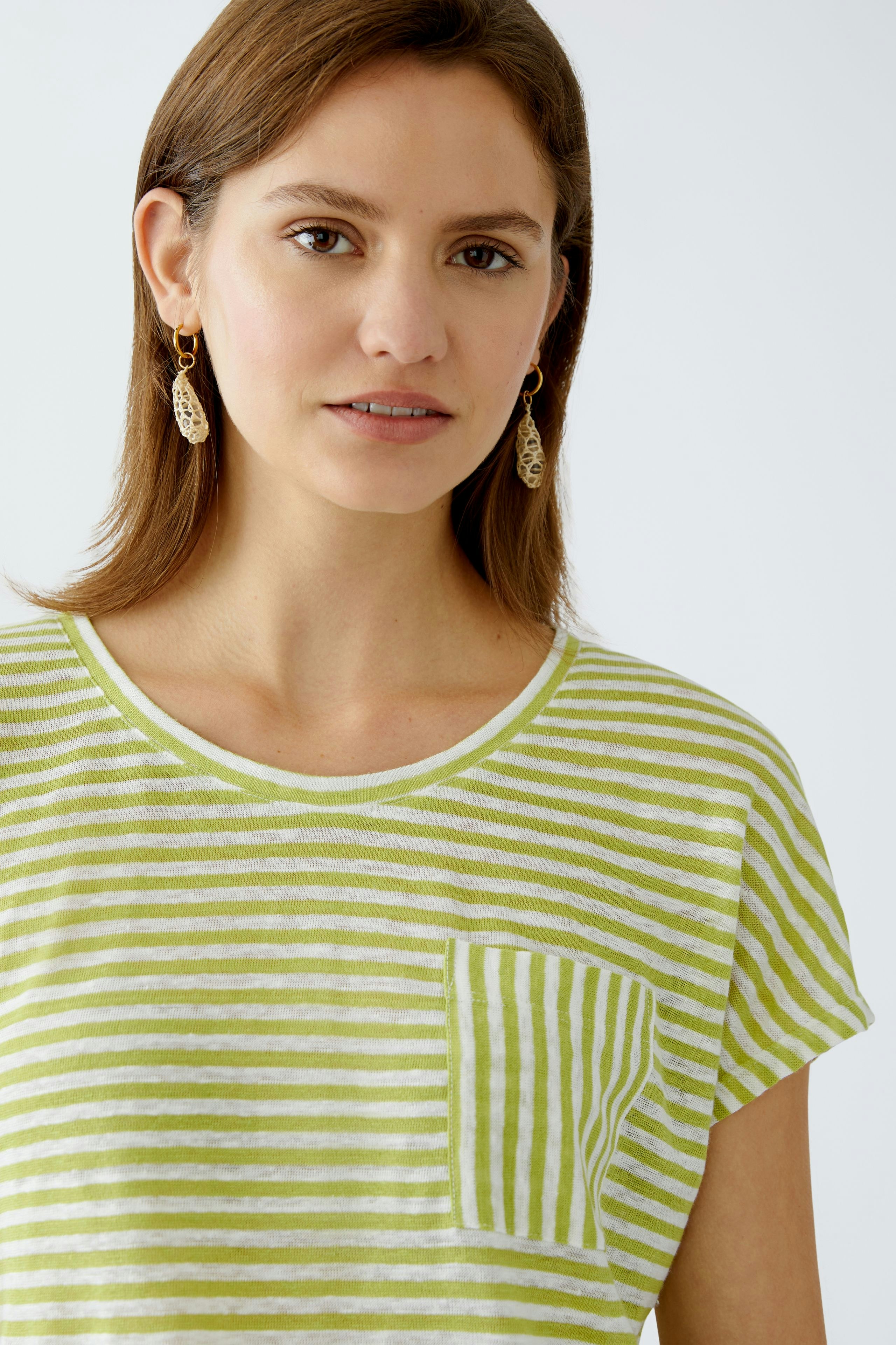 Damen-T-Shirt: Junge Frau in gestreiftem, grün-weißem Shirt mit Brusttasche lächelt freundlich.