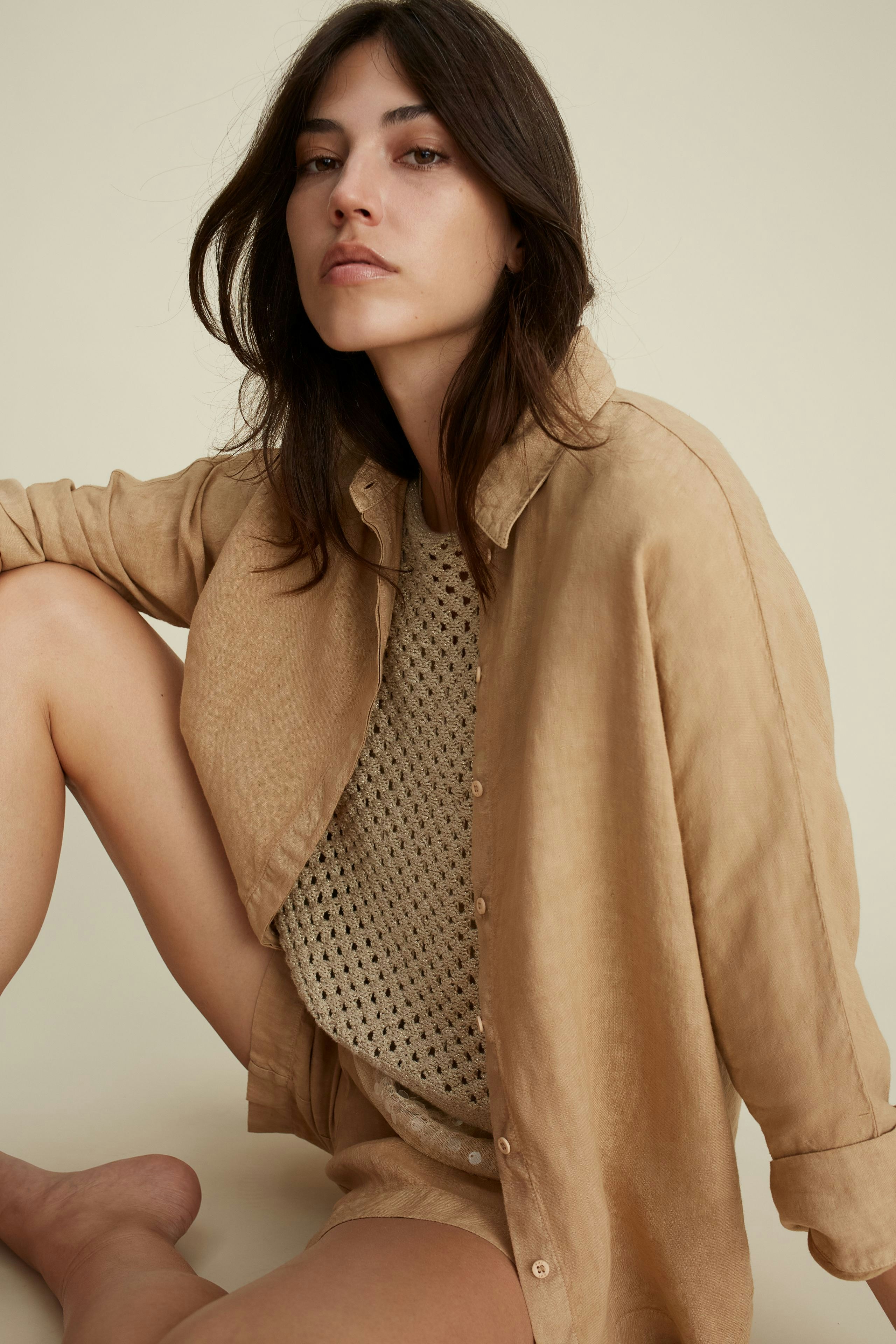 Stylish women's Bermuda shorts paired with a light, textured pullover, exuding casual elegance.