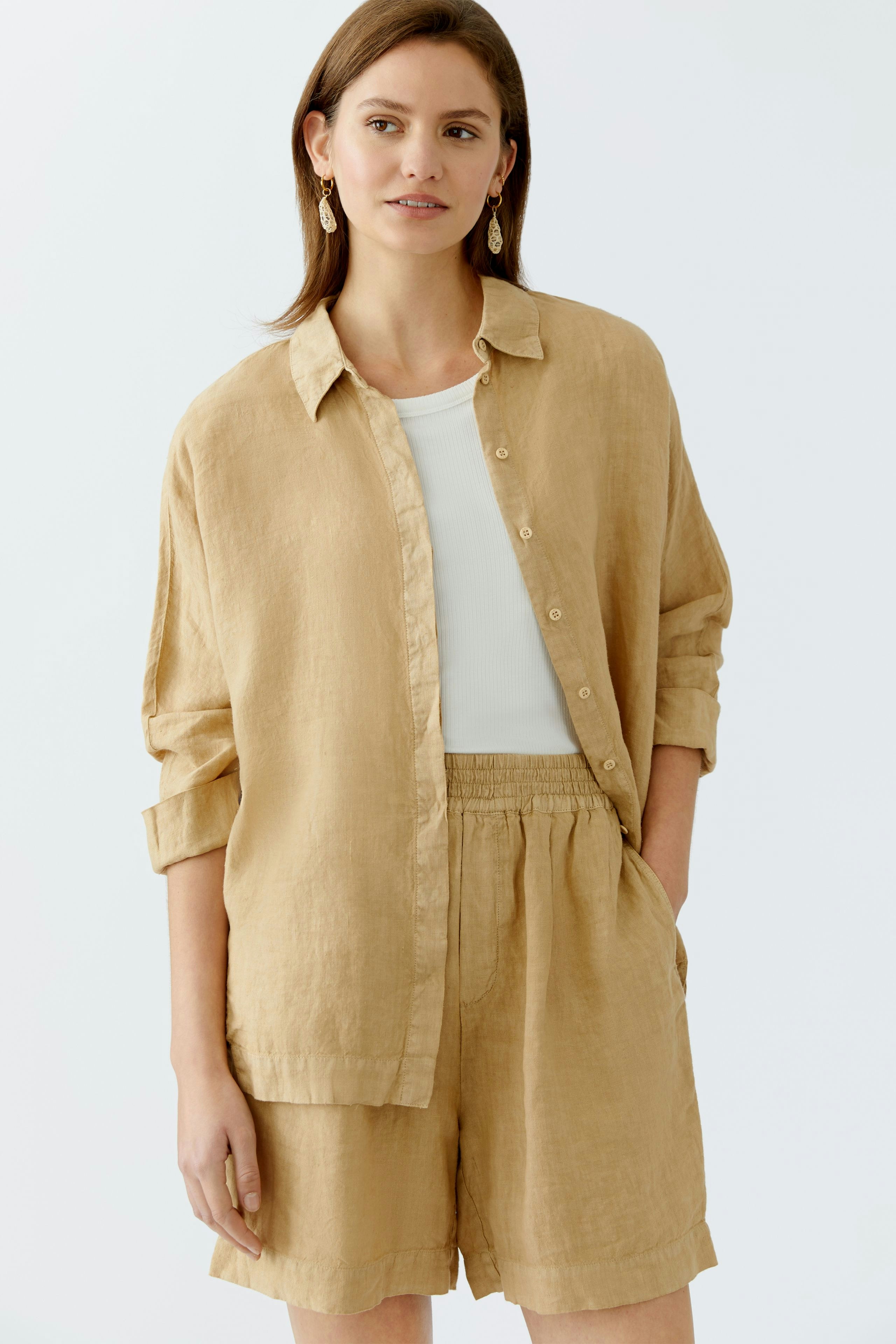 Stylish women's Bermuda shorts: A woman in a light beige outfit with a relaxed fit, perfect for summer.