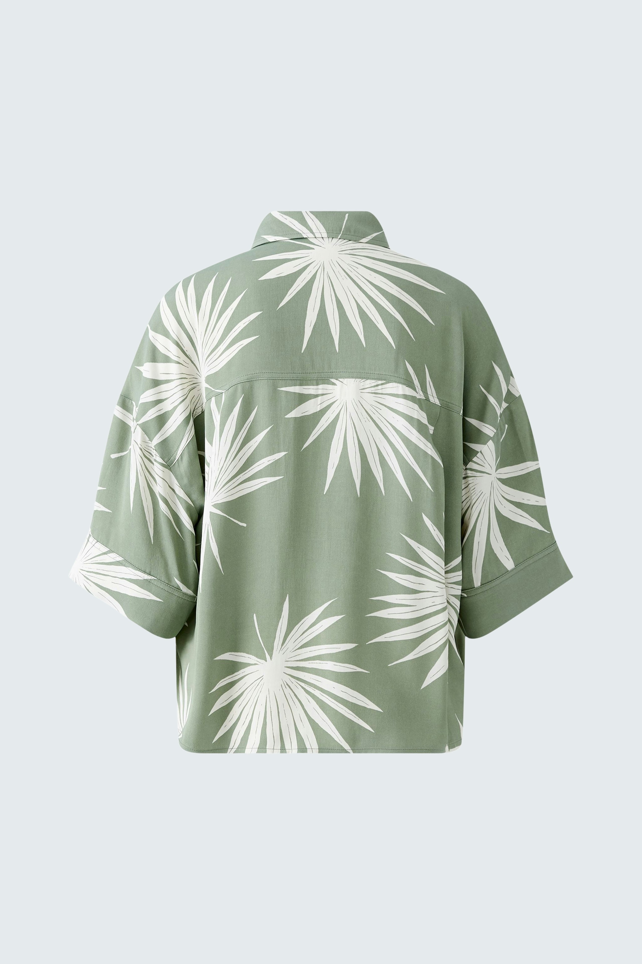 Stylish women's blouse: Back view of a green blouse with white leaf patterns, perfect for casual wear.