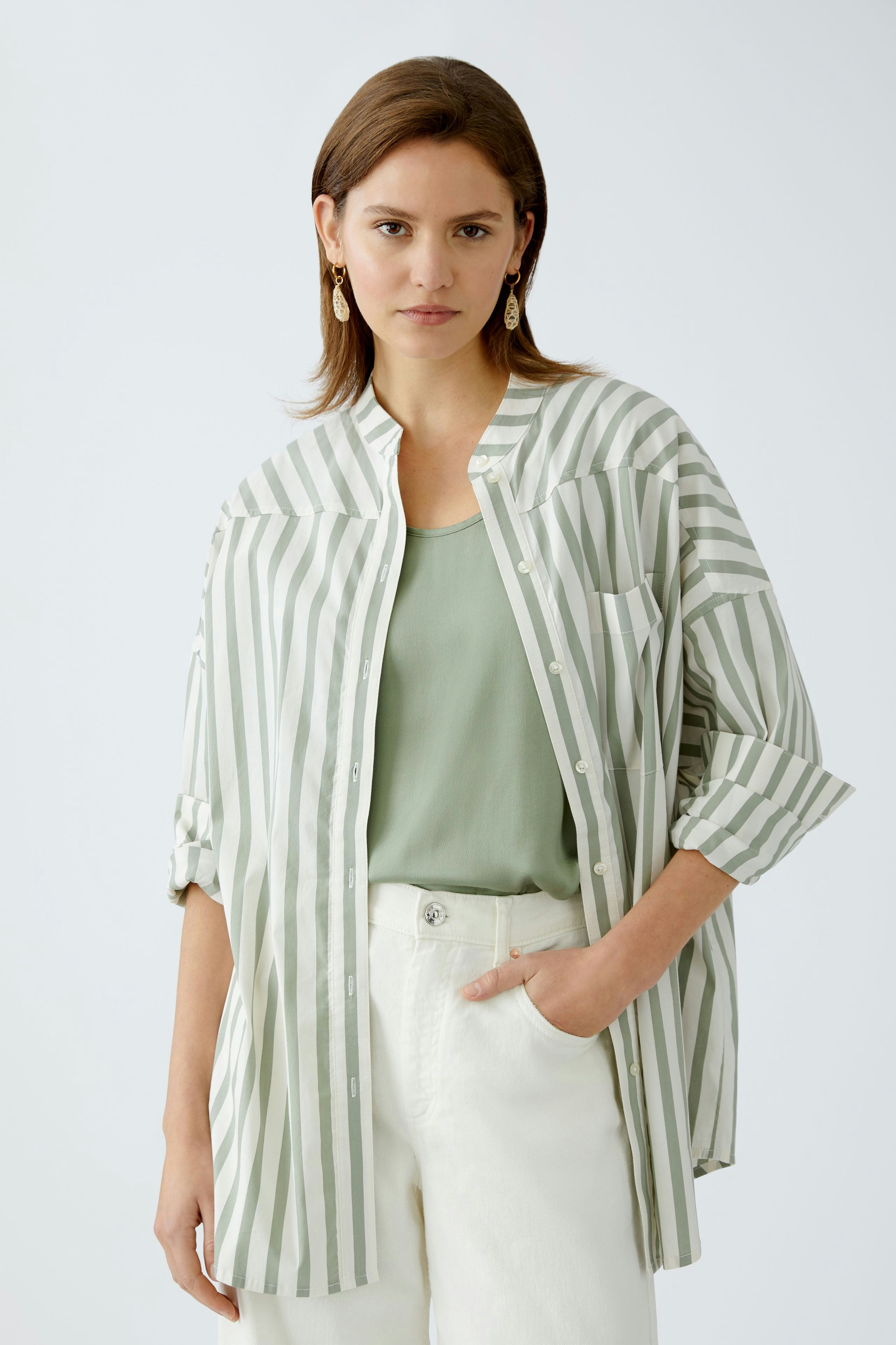 Lässige Damen-Bluse: Frau in gestreifter Bluse mit lockerer Passform und hellem Top.