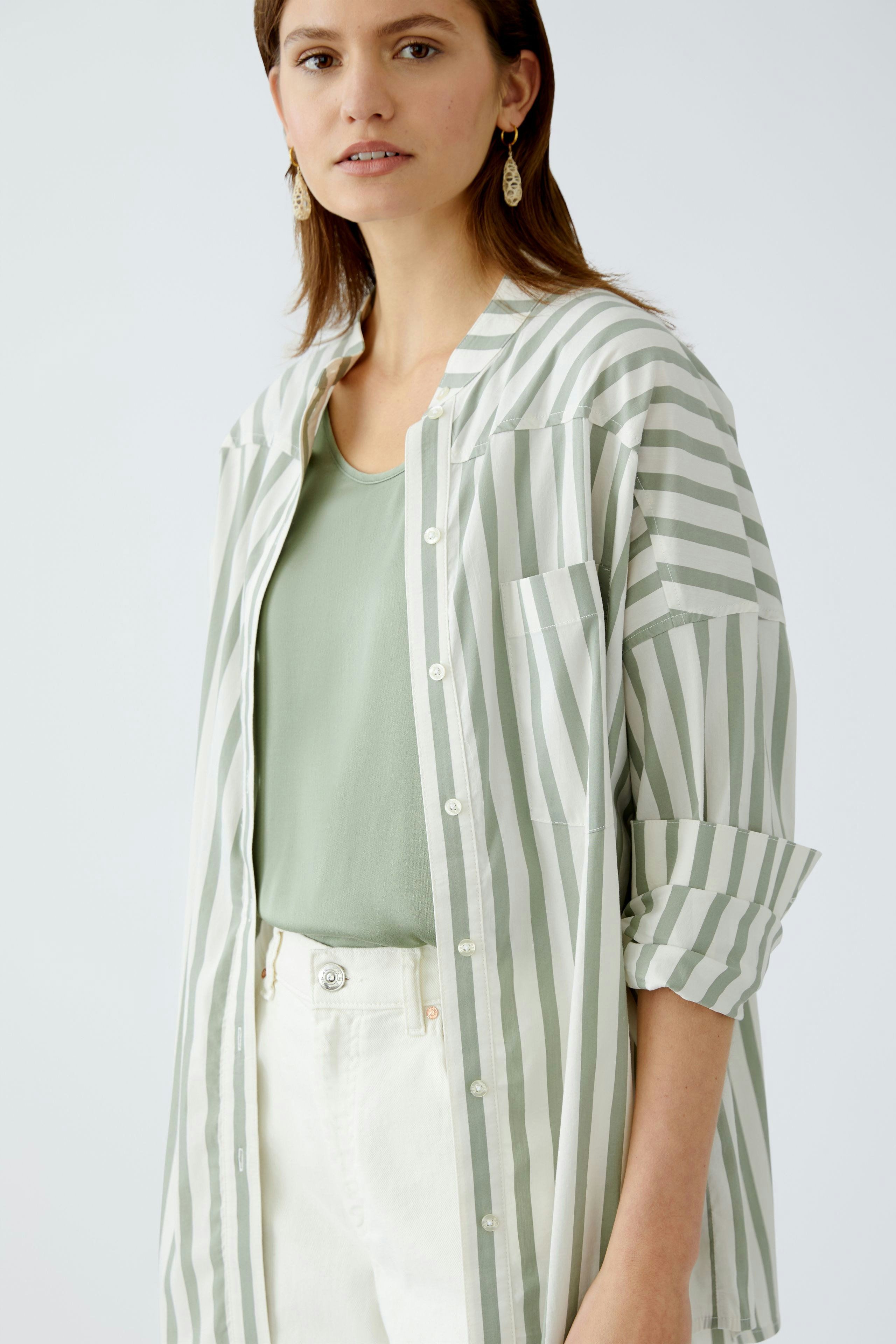 Moderne Damen-Bluse: Frau in gestreifter Bluse mit lässigem Schnitt und frischem Design.