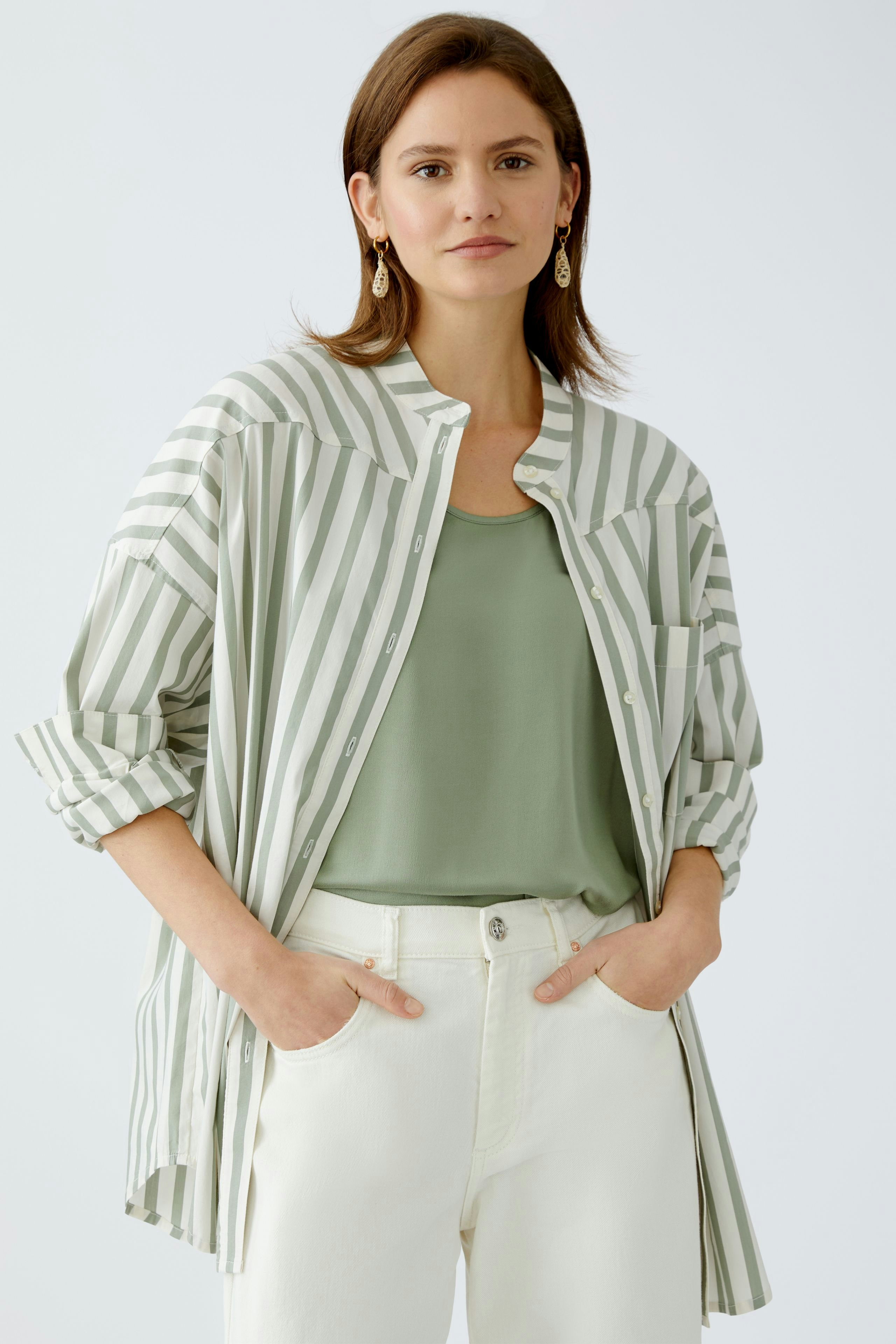 Moderne Damen-Bluse: Frau in gestreifter Bluse mit lässigem Top und hellen Hosen.