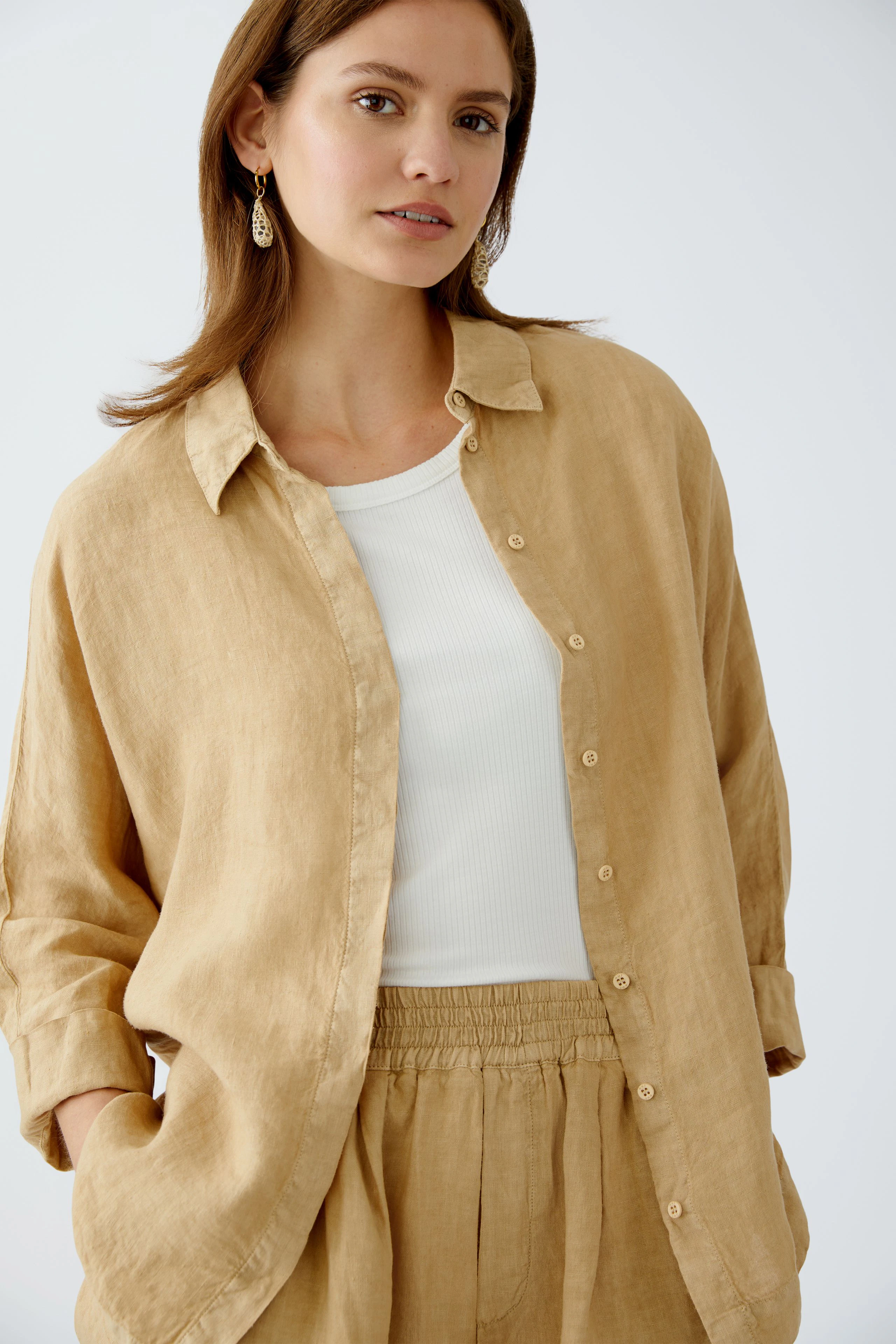 Stylish women's blouse: A woman in a light brown linen blouse, exuding effortless elegance.