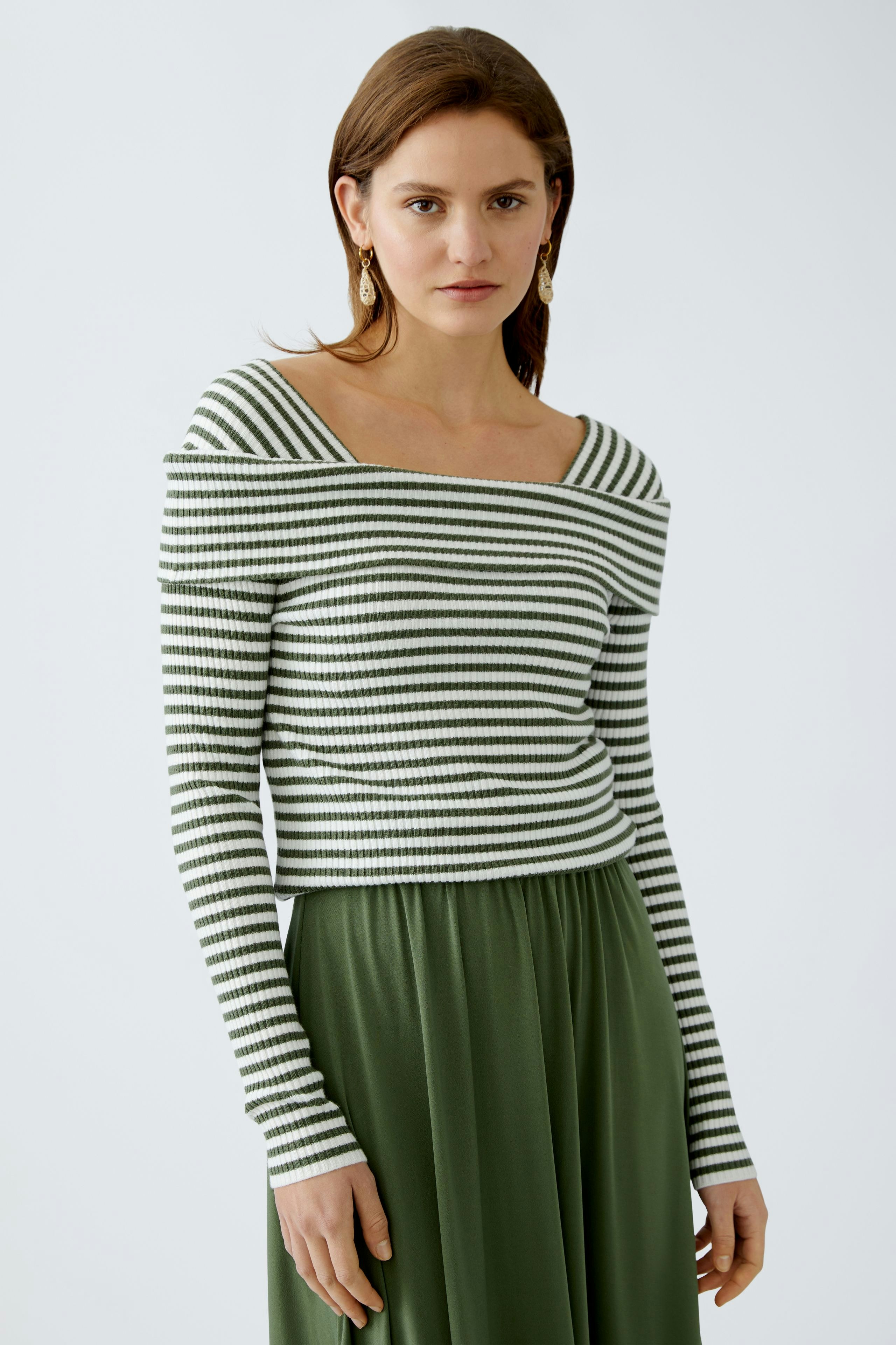 Damen-Pullover: Frau in gestreiftem Pullover mit weitem Ausschnitt und lässigem Look.