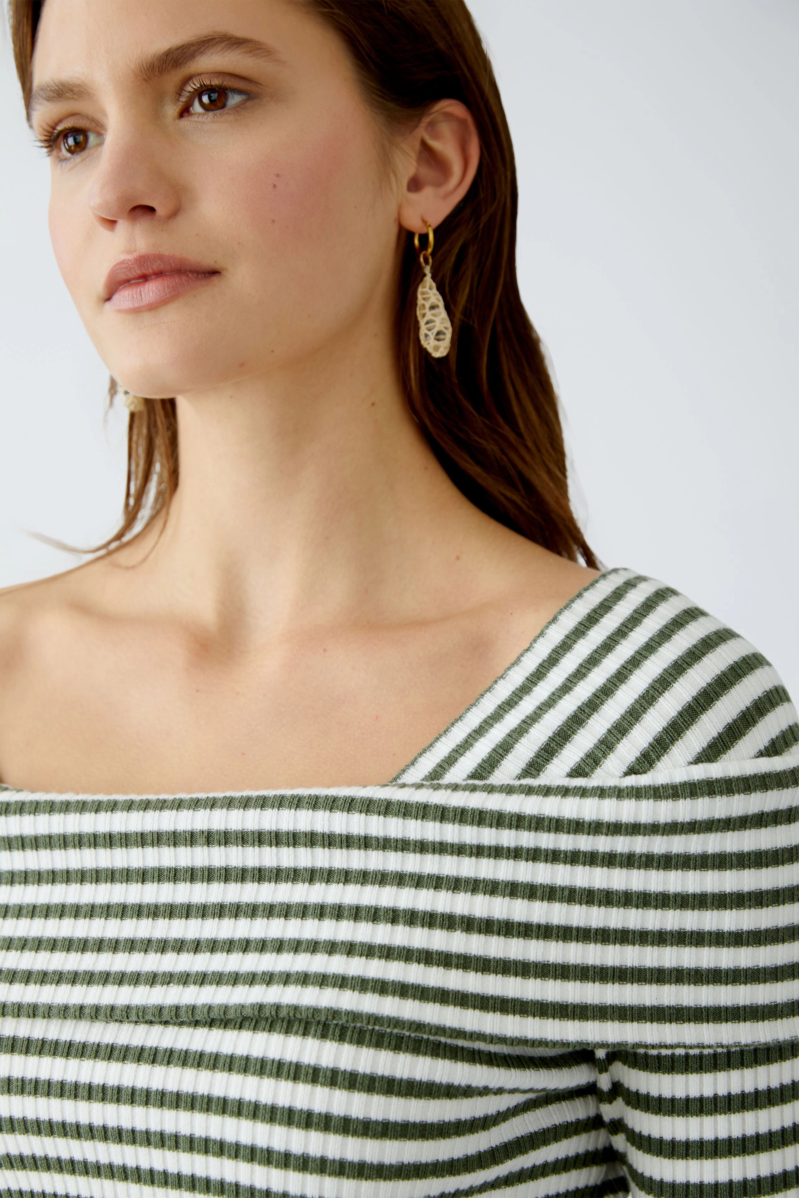 Damen-Pullover: Frau in gestreiftem, schulterfreiem Pullover mit elegantem Design.