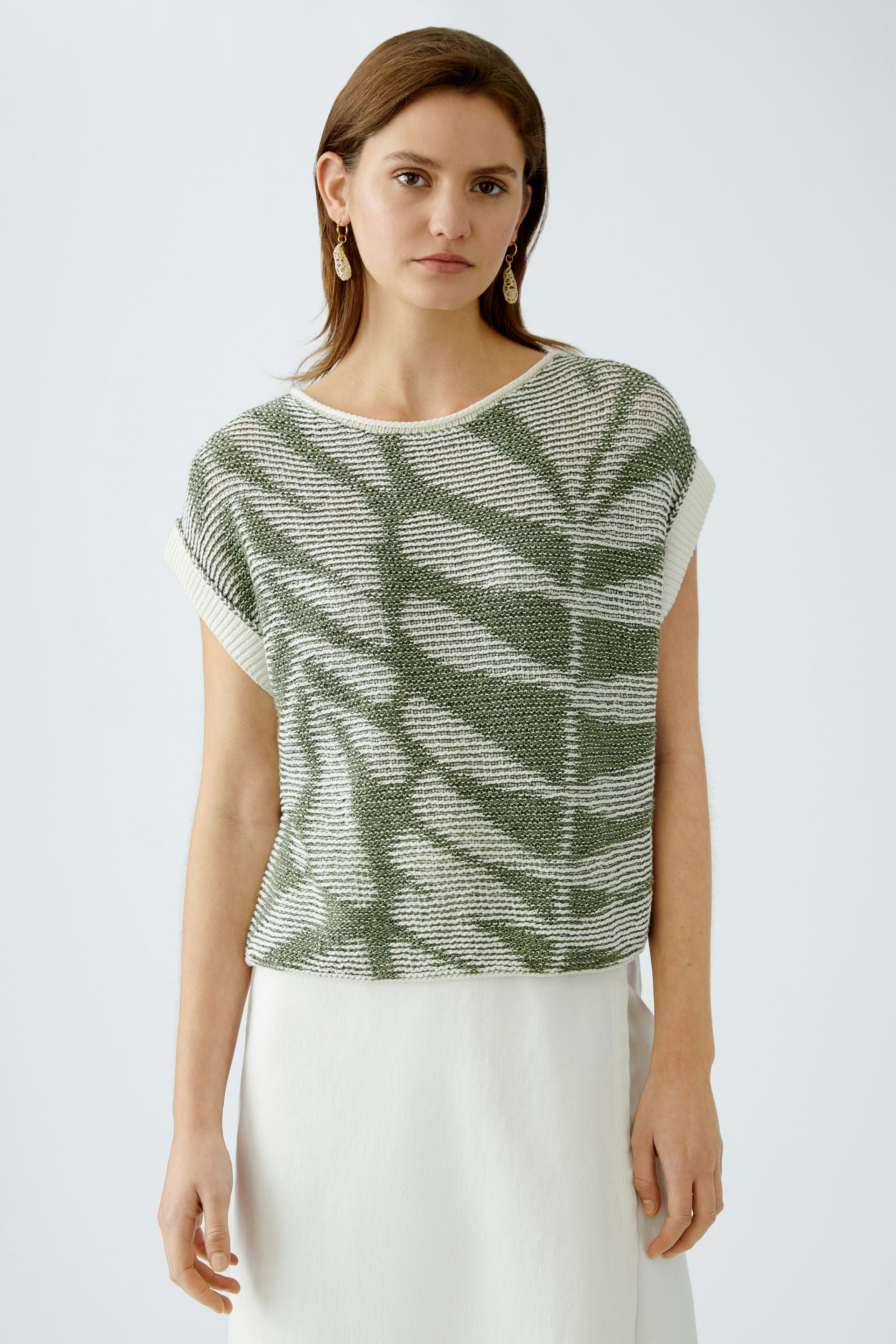 Stylish women's pullover: A woman in a green and white patterned pullover, exuding casual elegance.