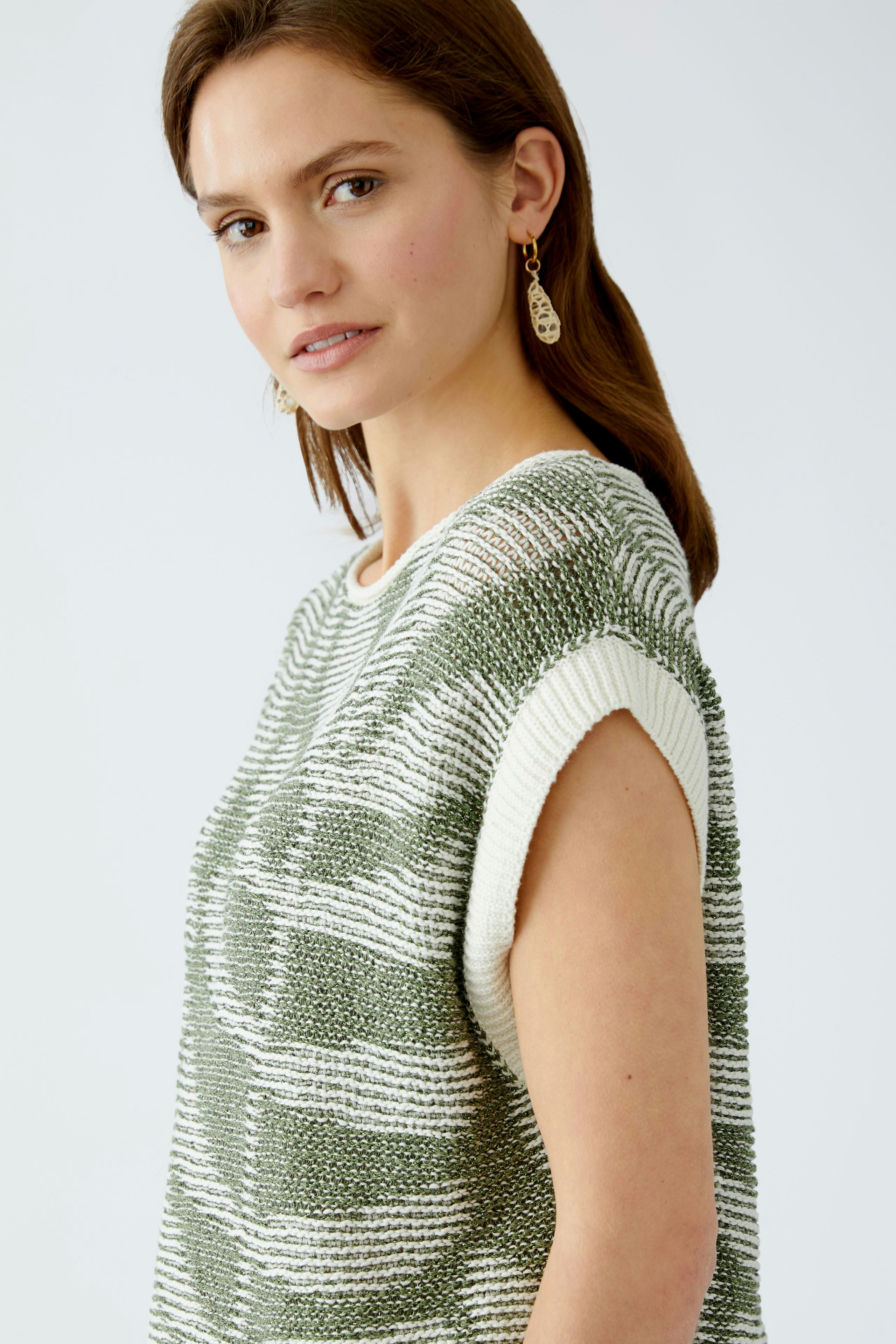 Stylish women's pullover: A woman in a green and white striped pullover, exuding casual elegance.