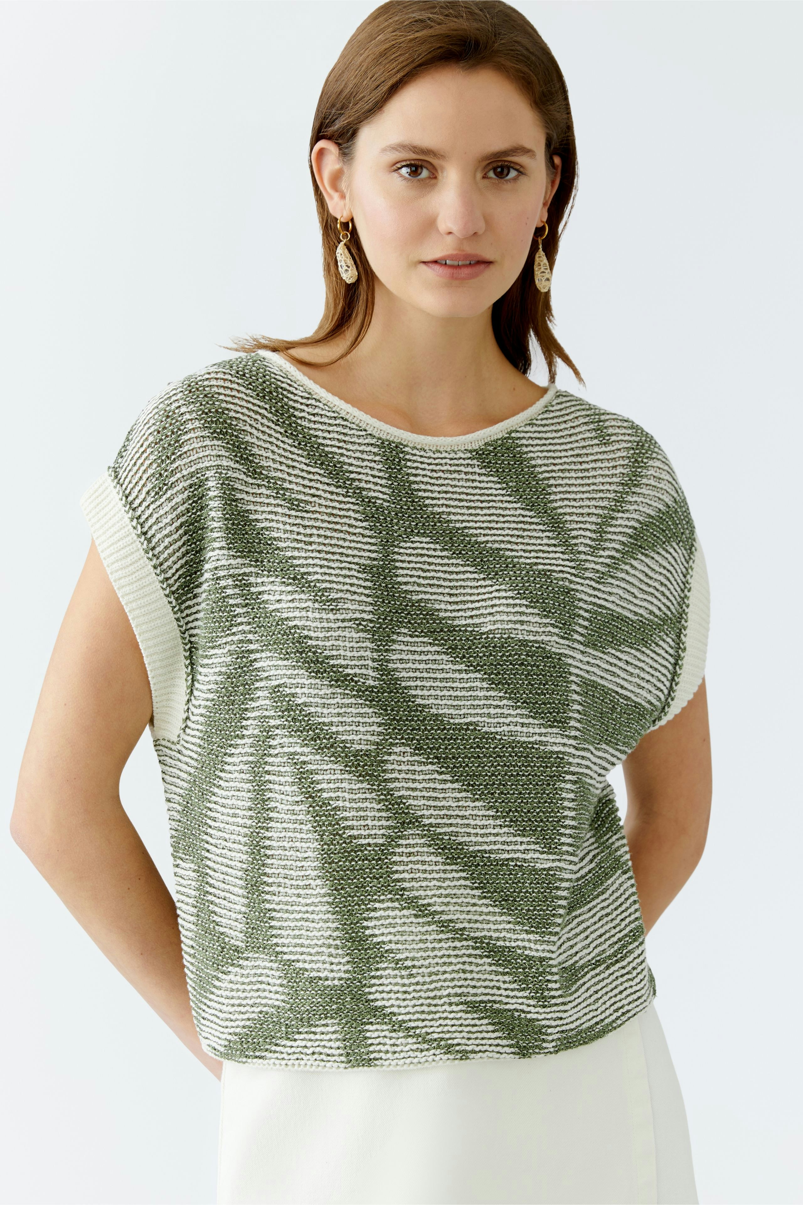 Stylish women's pullover: A woman in a green and white patterned pullover, exuding elegance.