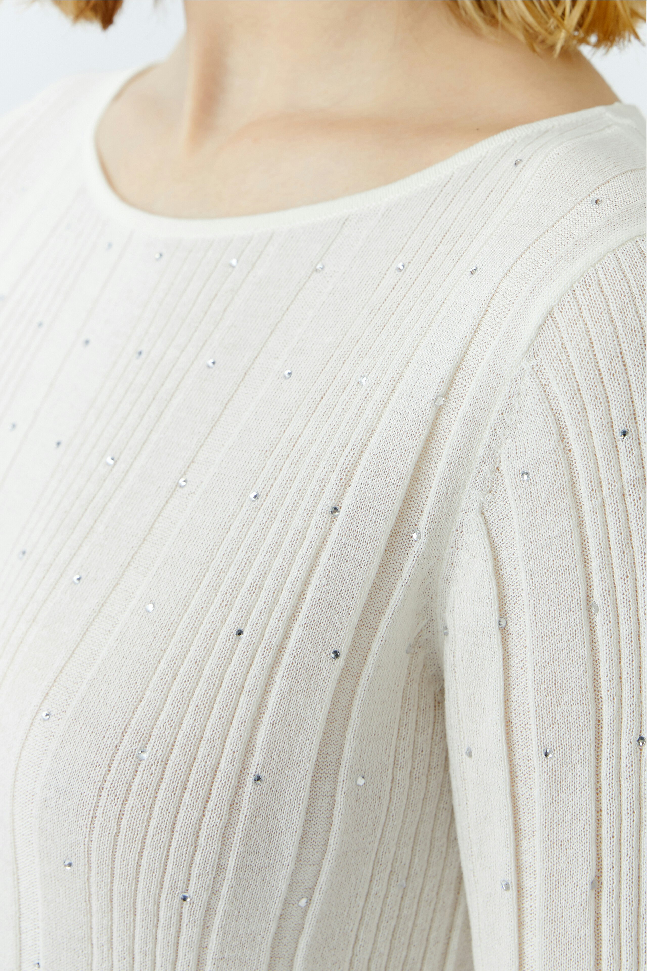 Eleganter Damen-Pullover in Creme mit feinen Rippstrukturen und glitzernden Akzenten.