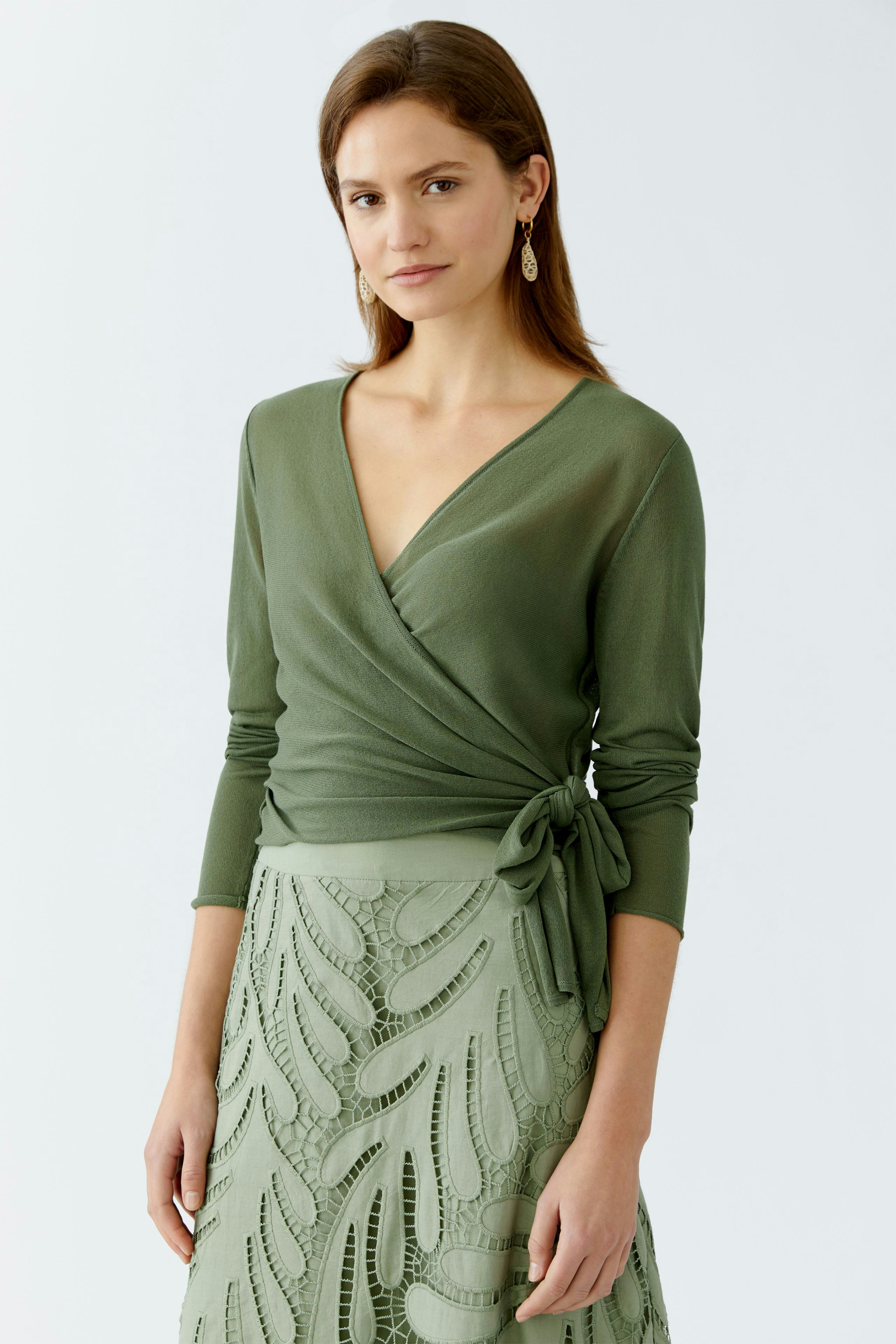 Elegante Damen-Strickjacke in sanftem Grün, mit Wickeldesign und taillierter Passform.