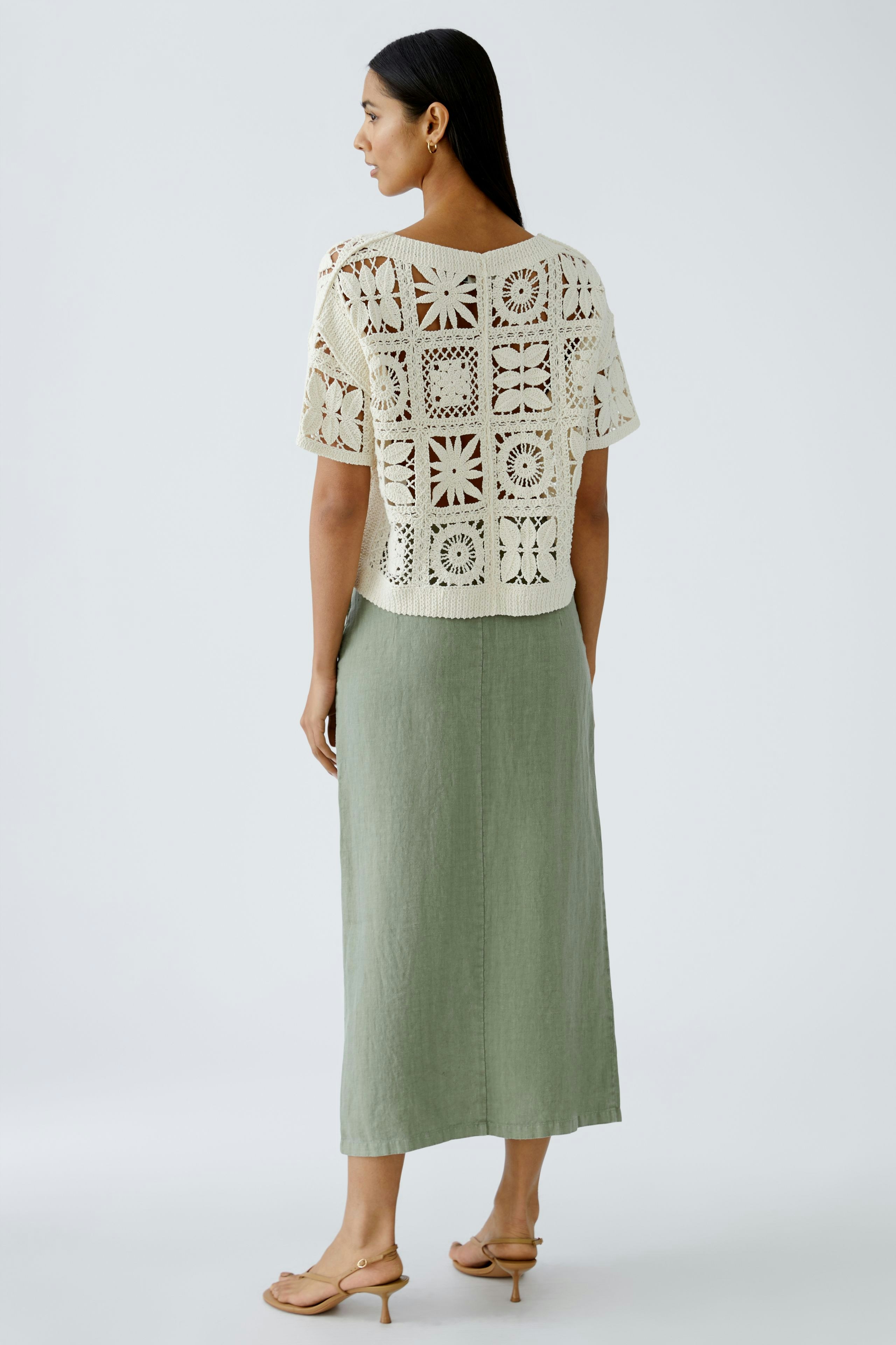 Stylish women's pullover: A woman in a cream crochet pullover with a relaxed fit, paired with a long skirt.