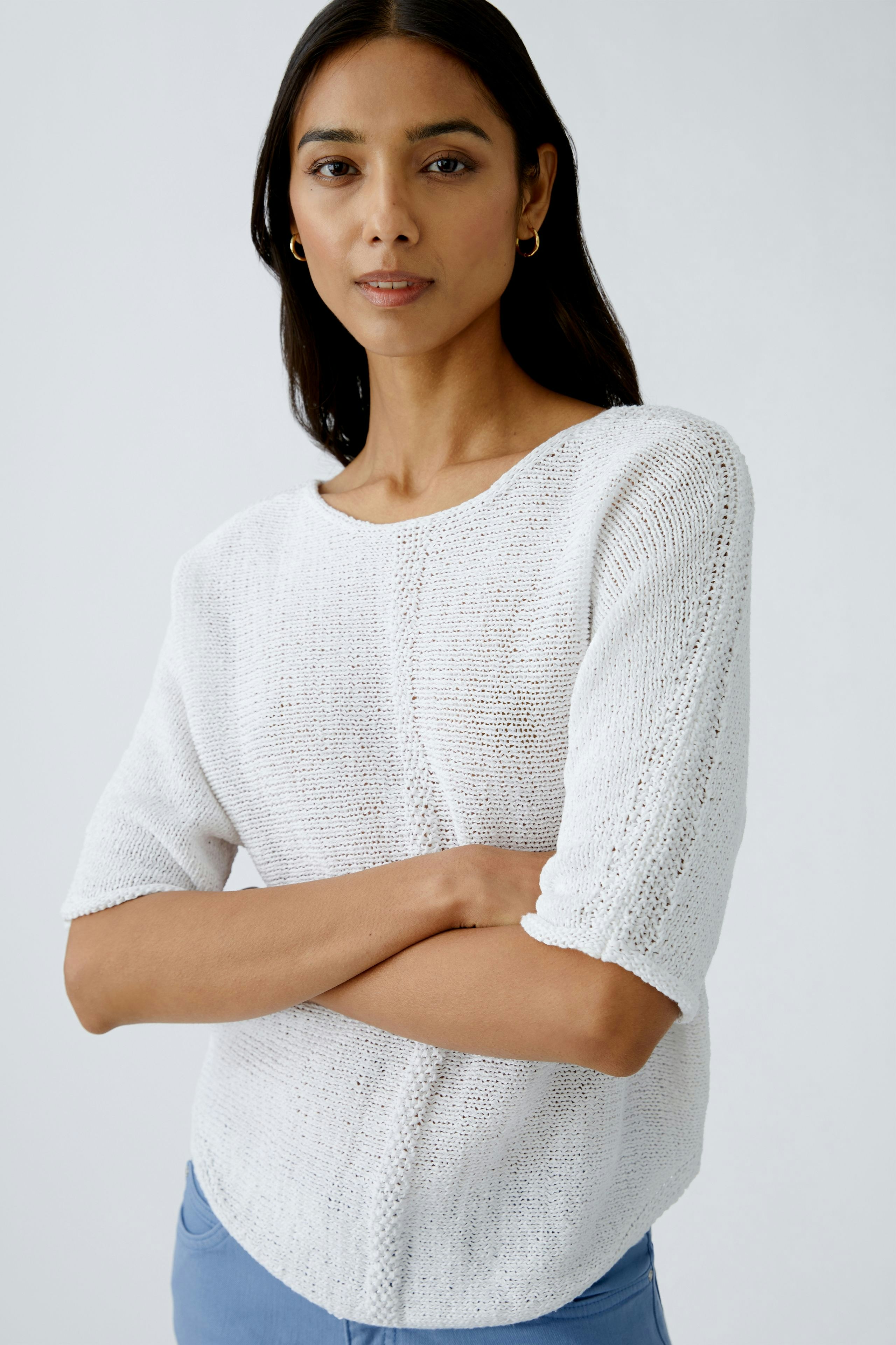 Eleganter Damen-Pullover: Frau in weißem, leichtem Strickpullover mit kurzen Ärmeln.