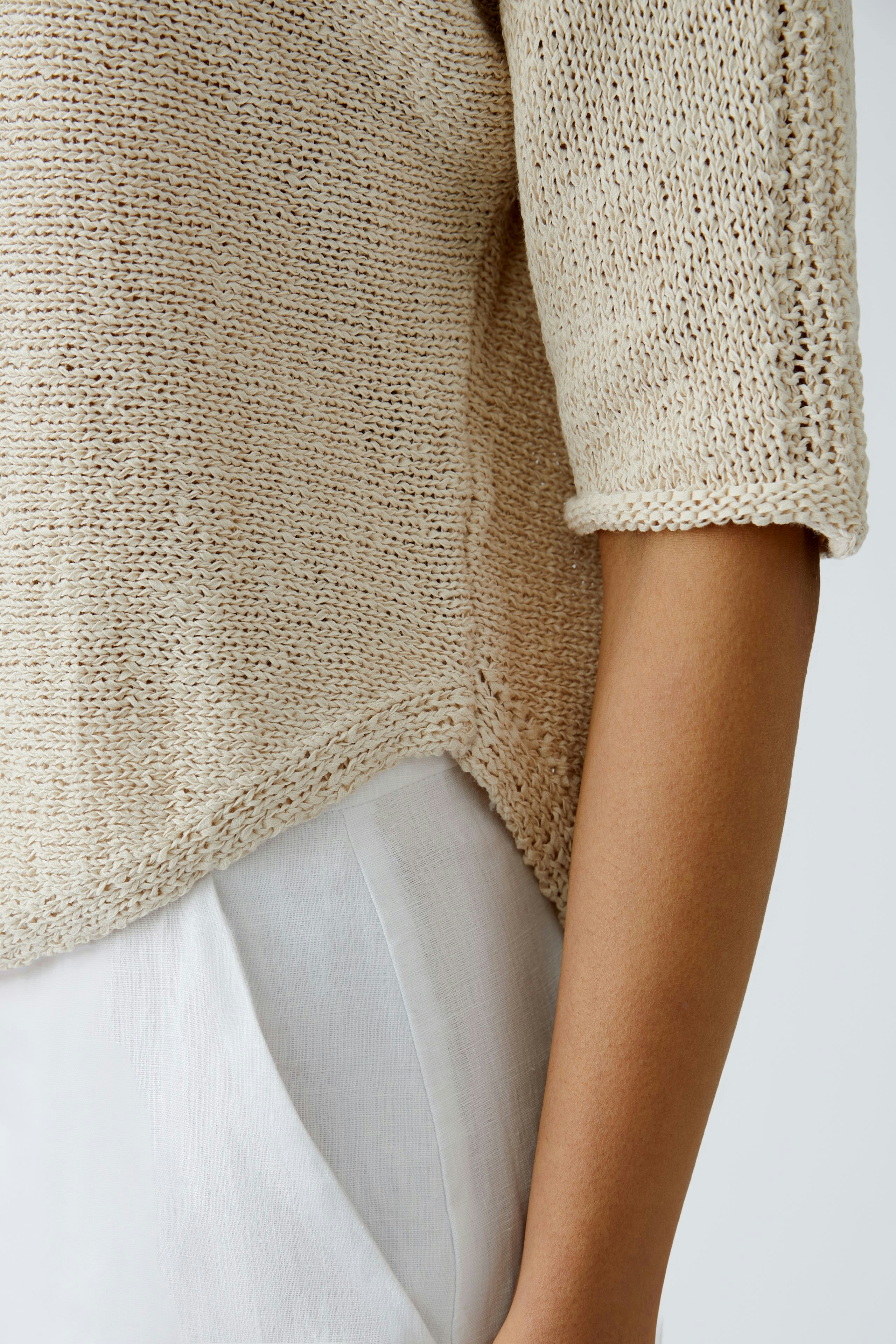 Beiger Damen-Pullover: Frau trägt einen lässigen, luftigen Strickpullover mit kurzen Ärmeln.