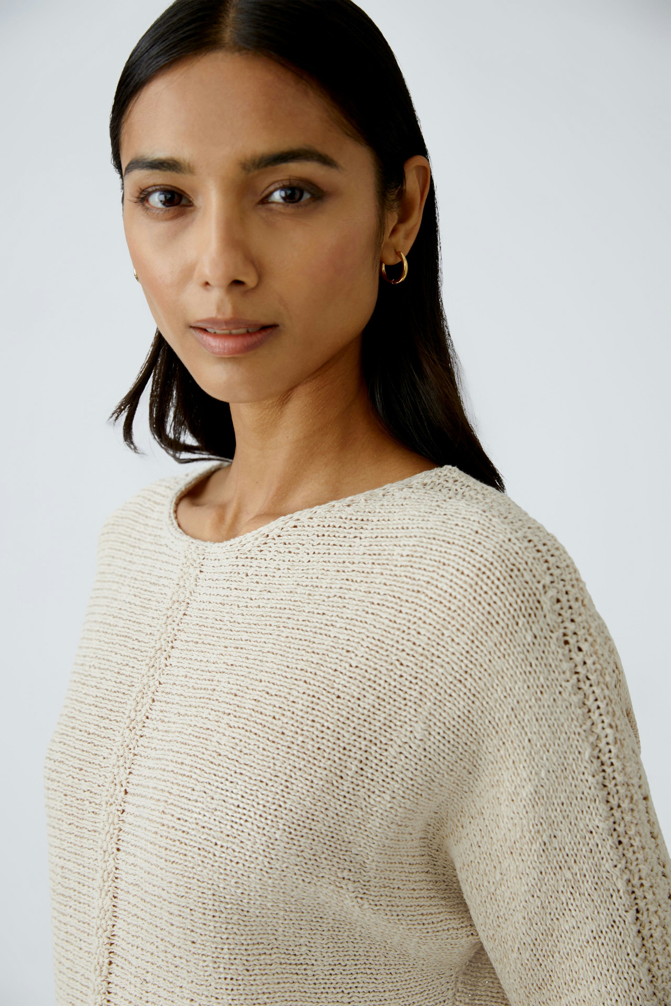 Eleganter Damen-Pullover: Frau mit hellem, strukturiertem Pullover und natürlichem Look.