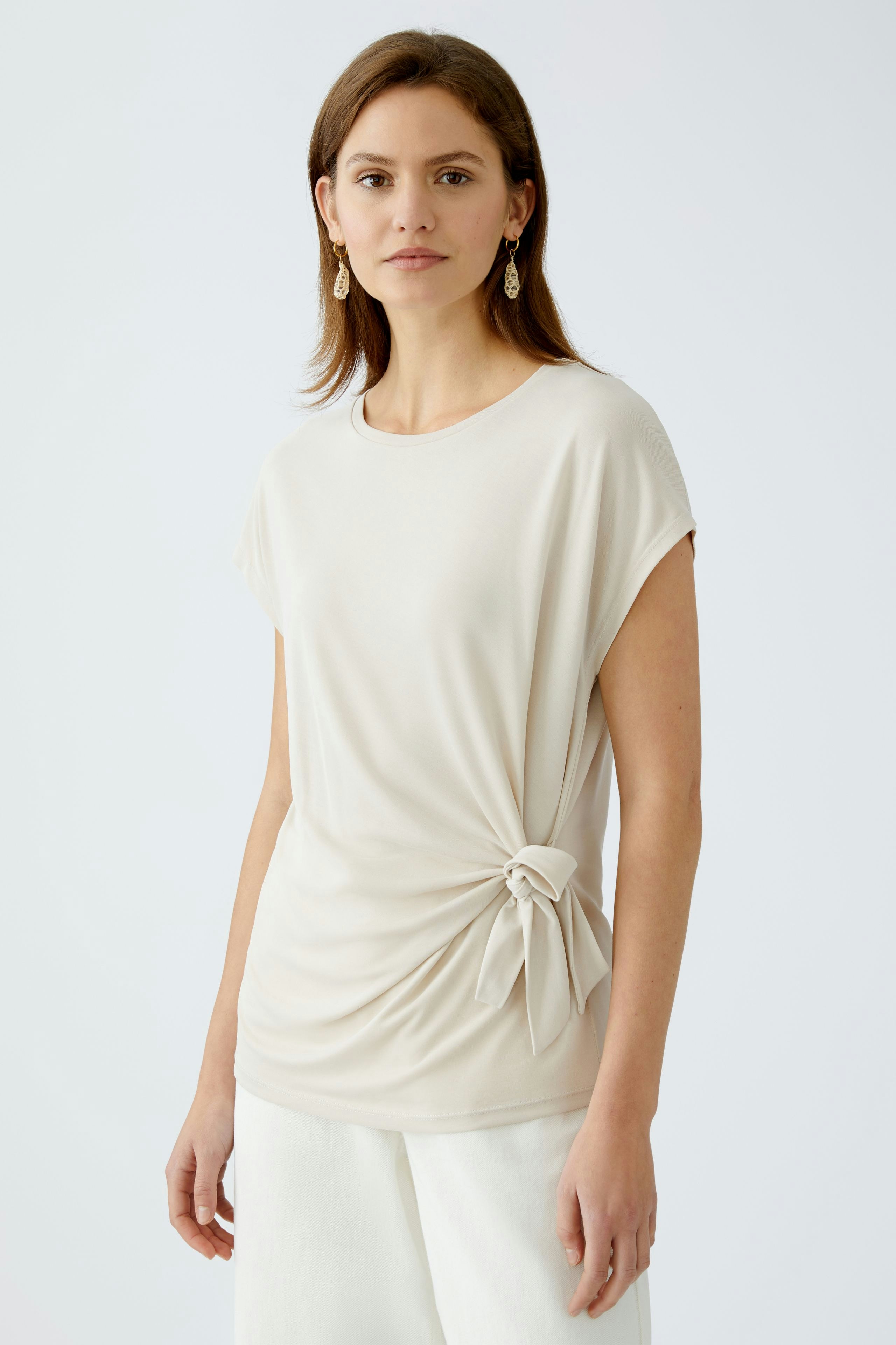 Elegantes Damen-T-Shirt in hellem Beige mit seitlichem Knoten, lässig und modern.