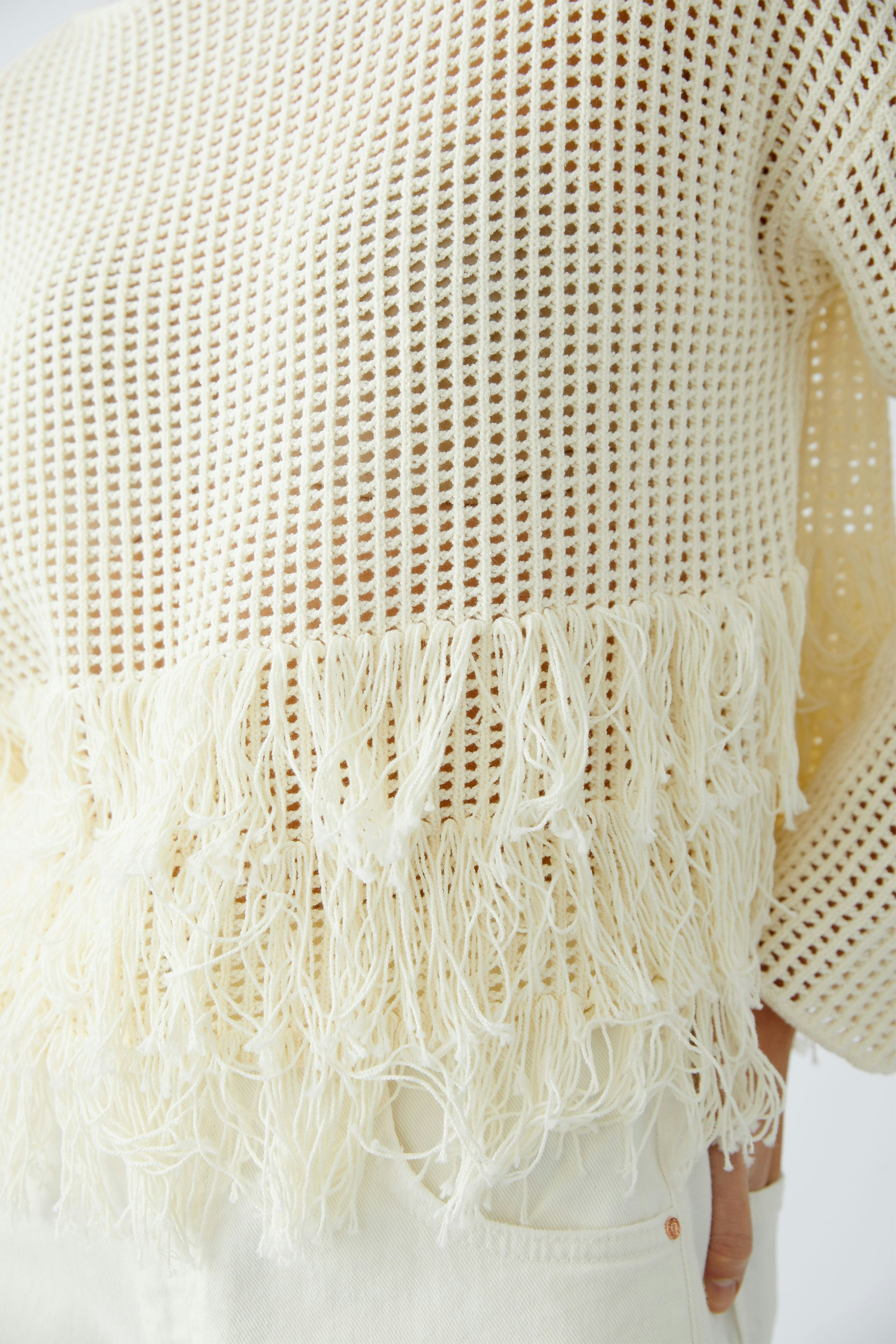 Damen-Pullover: Weiße Strickoptik mit fransigem Saum, lässig und modern.